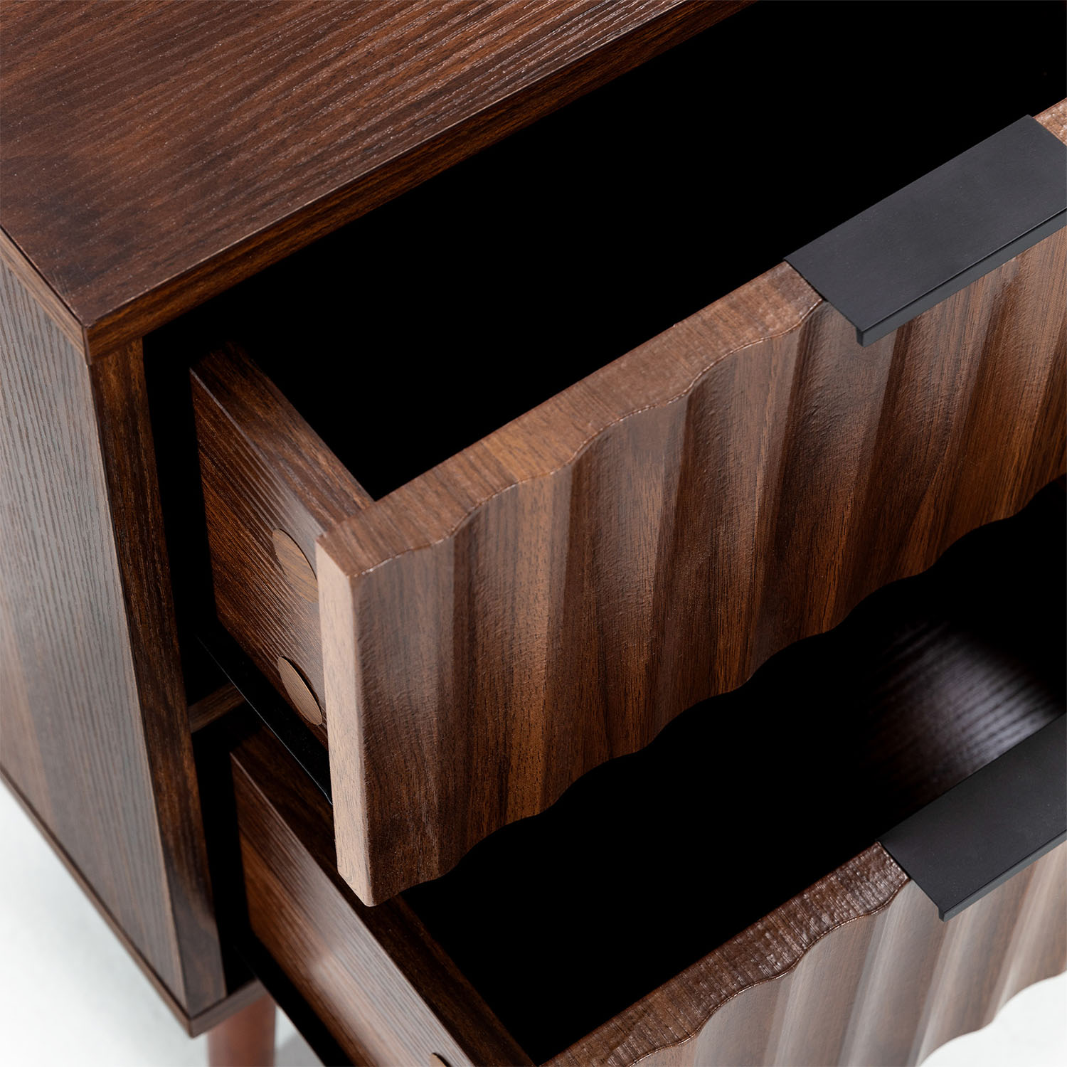 Cómoda de madera marrón con frentes de cajón acanalados y tiradores negros.