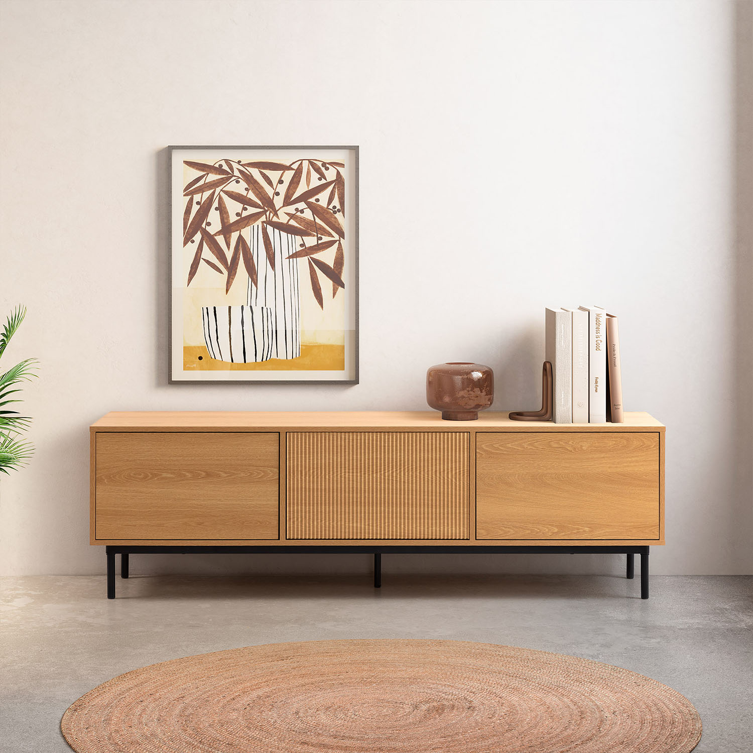 Un aparador de madera con obra de arte y libros.