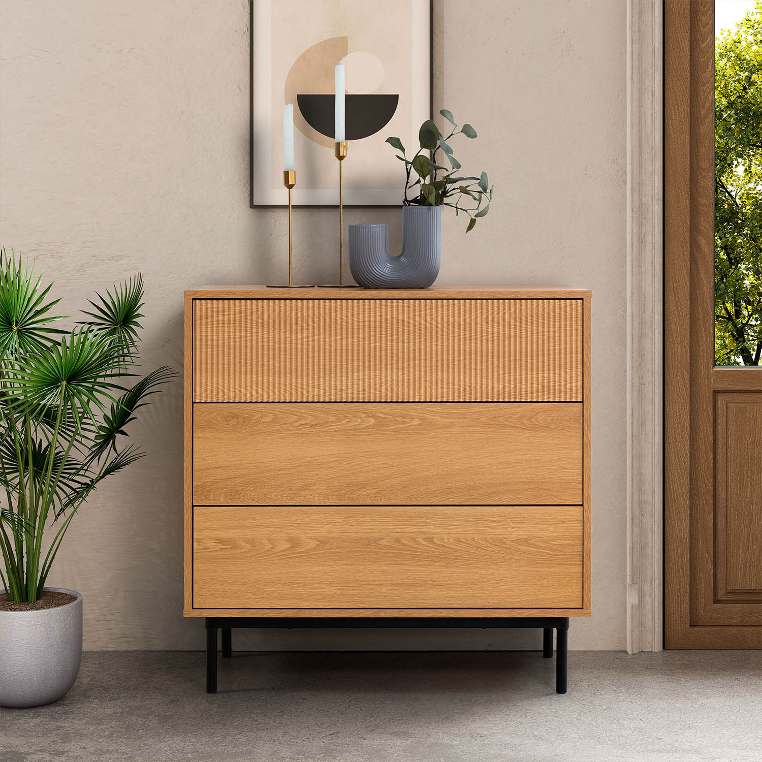 Una cómoda de madera con tres cajones está junto a una planta.