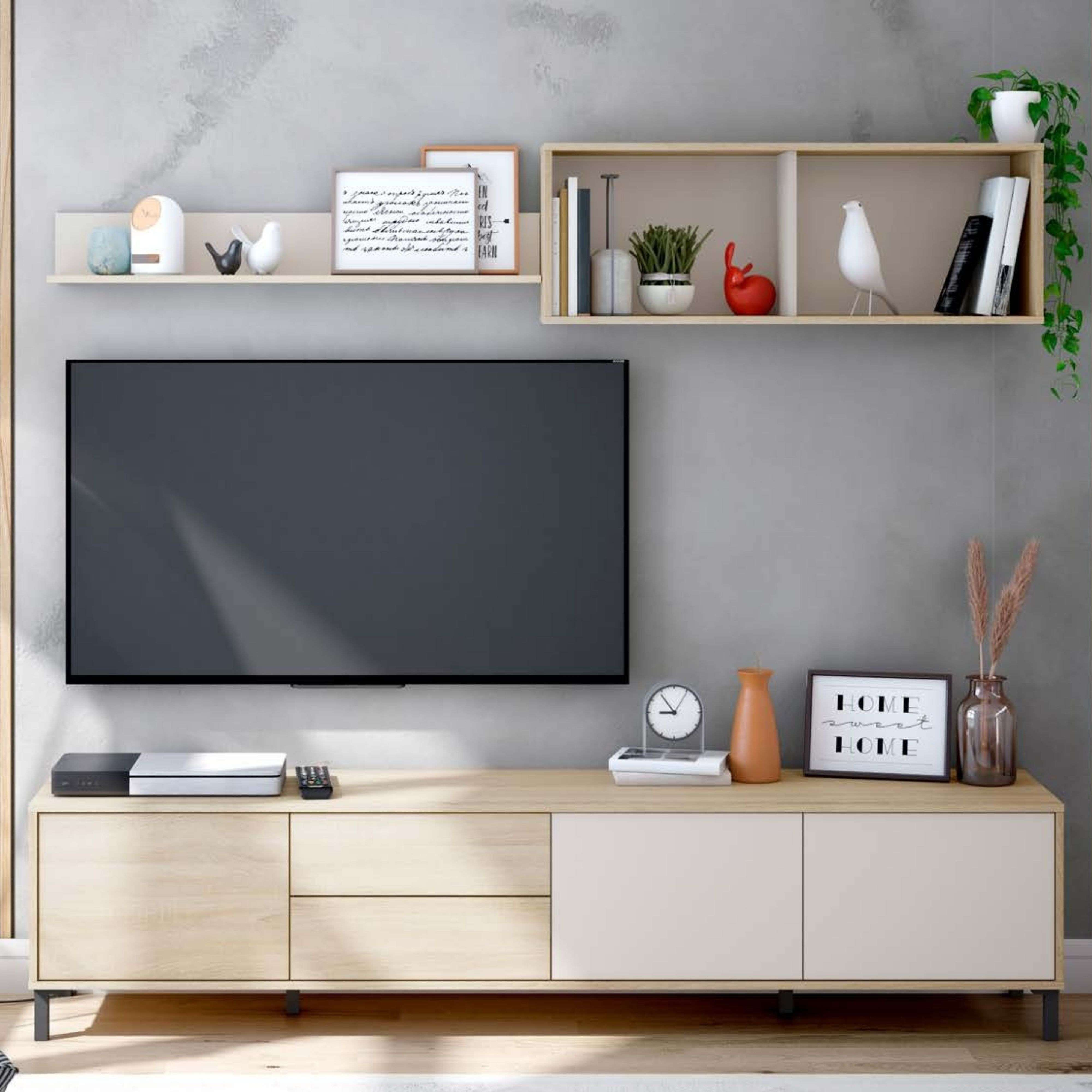 Un televisor sobre un aparador de madera clara con decoraciones.