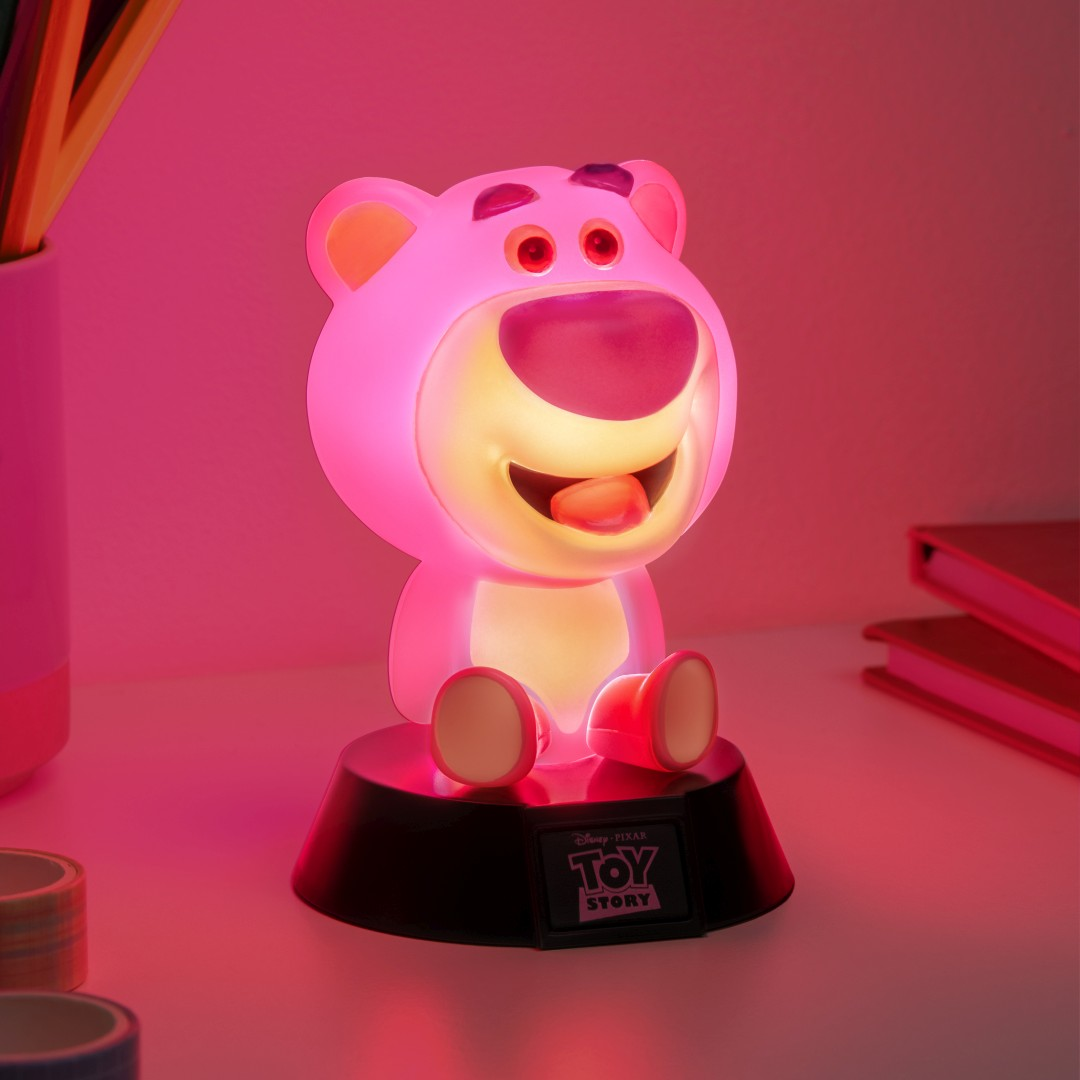 Różowa figurka Lotso z logo "Toy Story" świeci w ciemności.