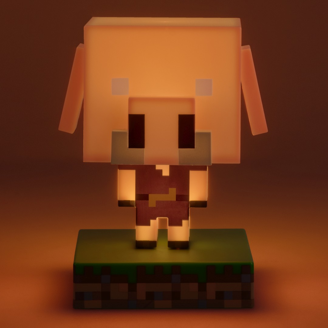 Świecąca świnka Minecraft na bloku trawy, oświetlona na pomarańczowo.