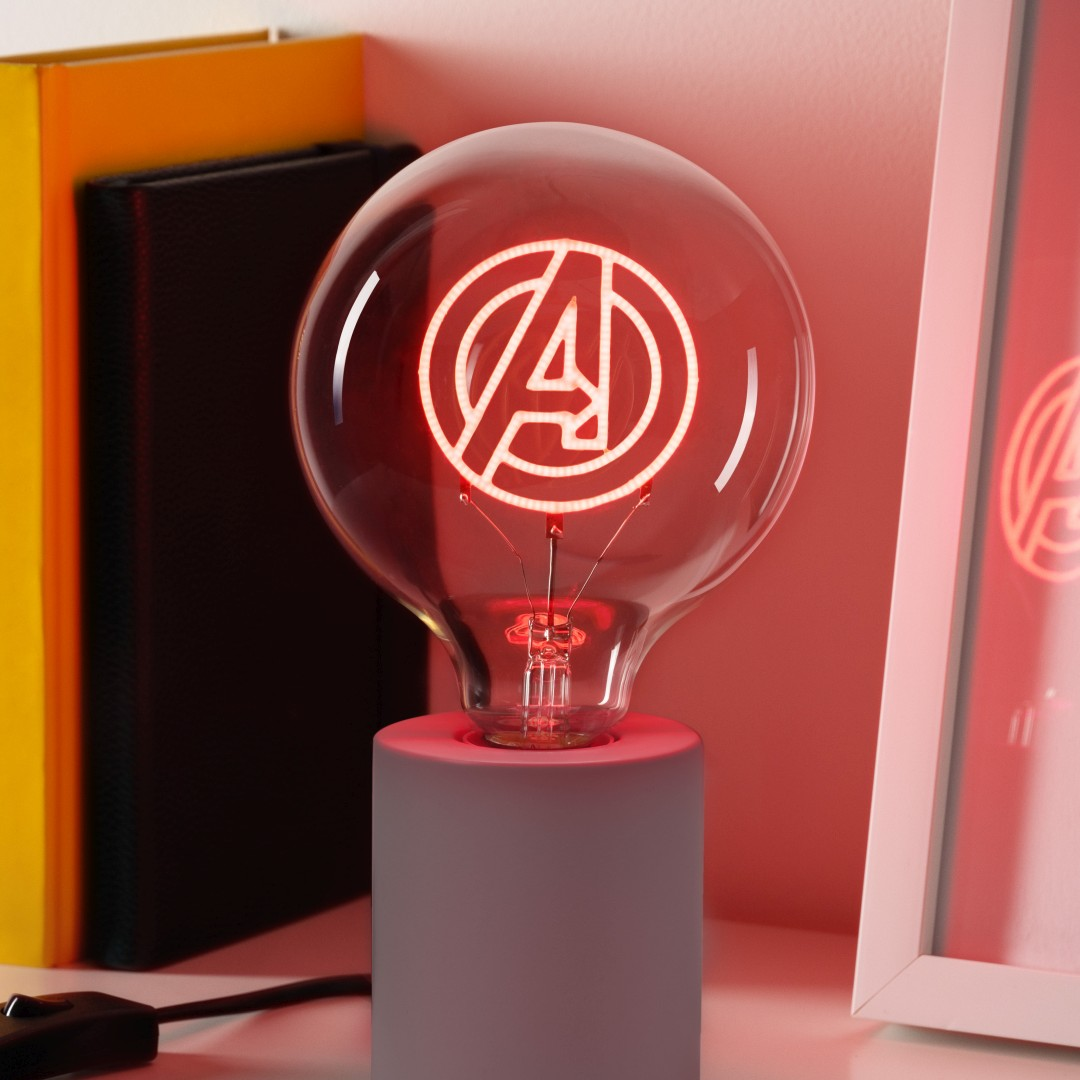 Żarówka z logo Avengers świeci na czerwono na szarej podstawie.