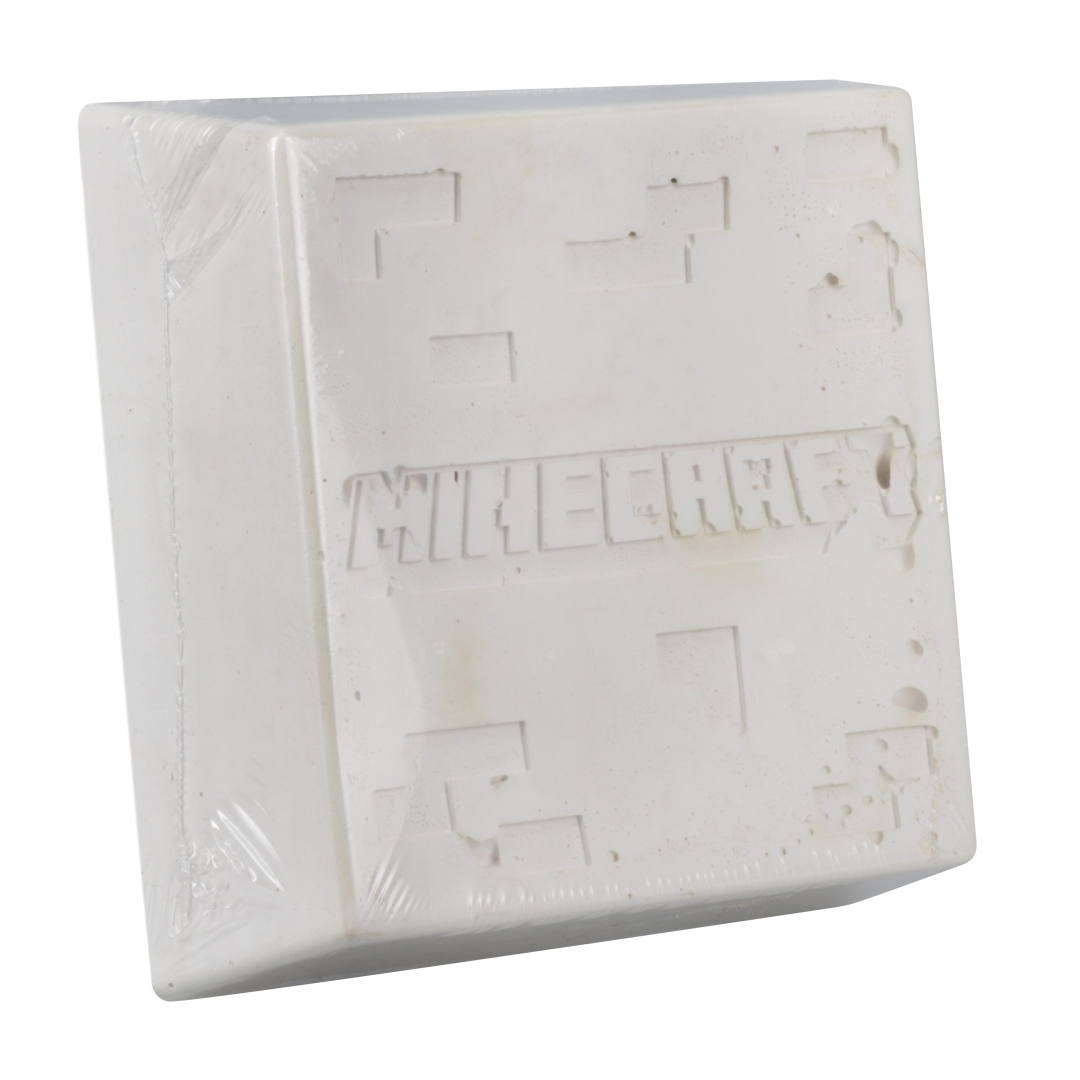 Ein weißer Minecraft-Block in Plastik verpackt, mit geprägtem Logo.