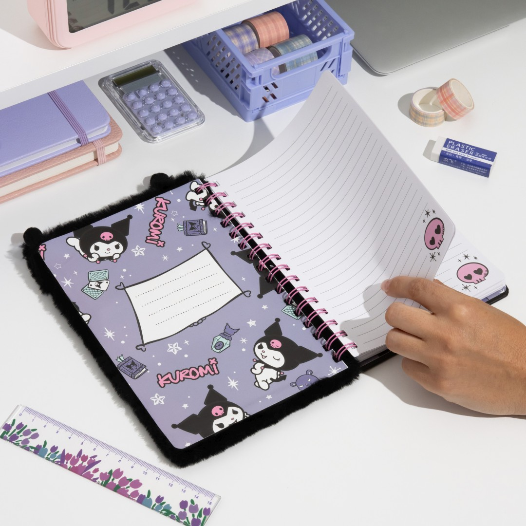Ein Notizbuch mit Kuromi-Motiv, aufgeschlagen, mit linierten Seiten. Schwarz-lila Muster.
