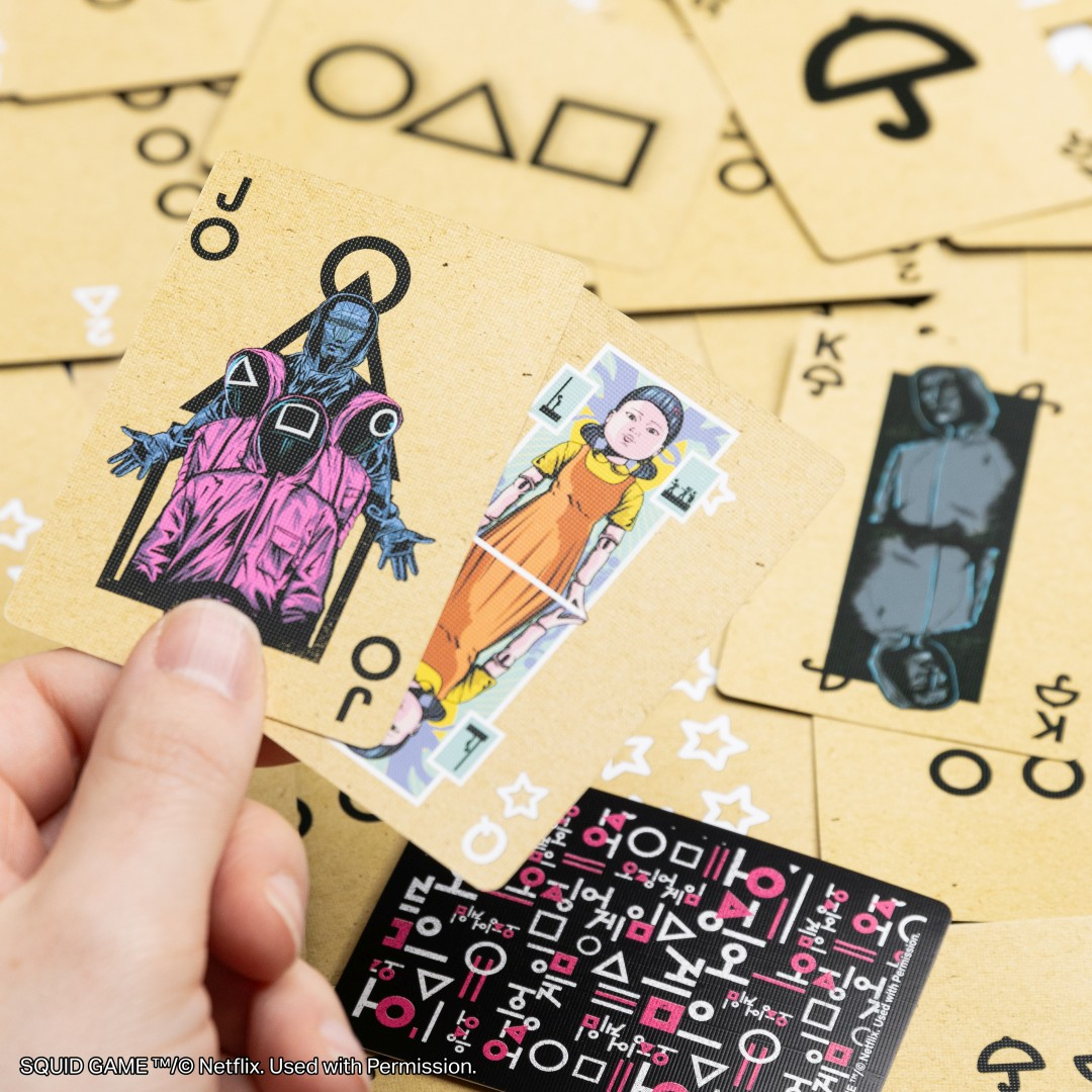 Carte da gioco con motivi di Squid Game: guardia, bambina, giocatore e simboli.