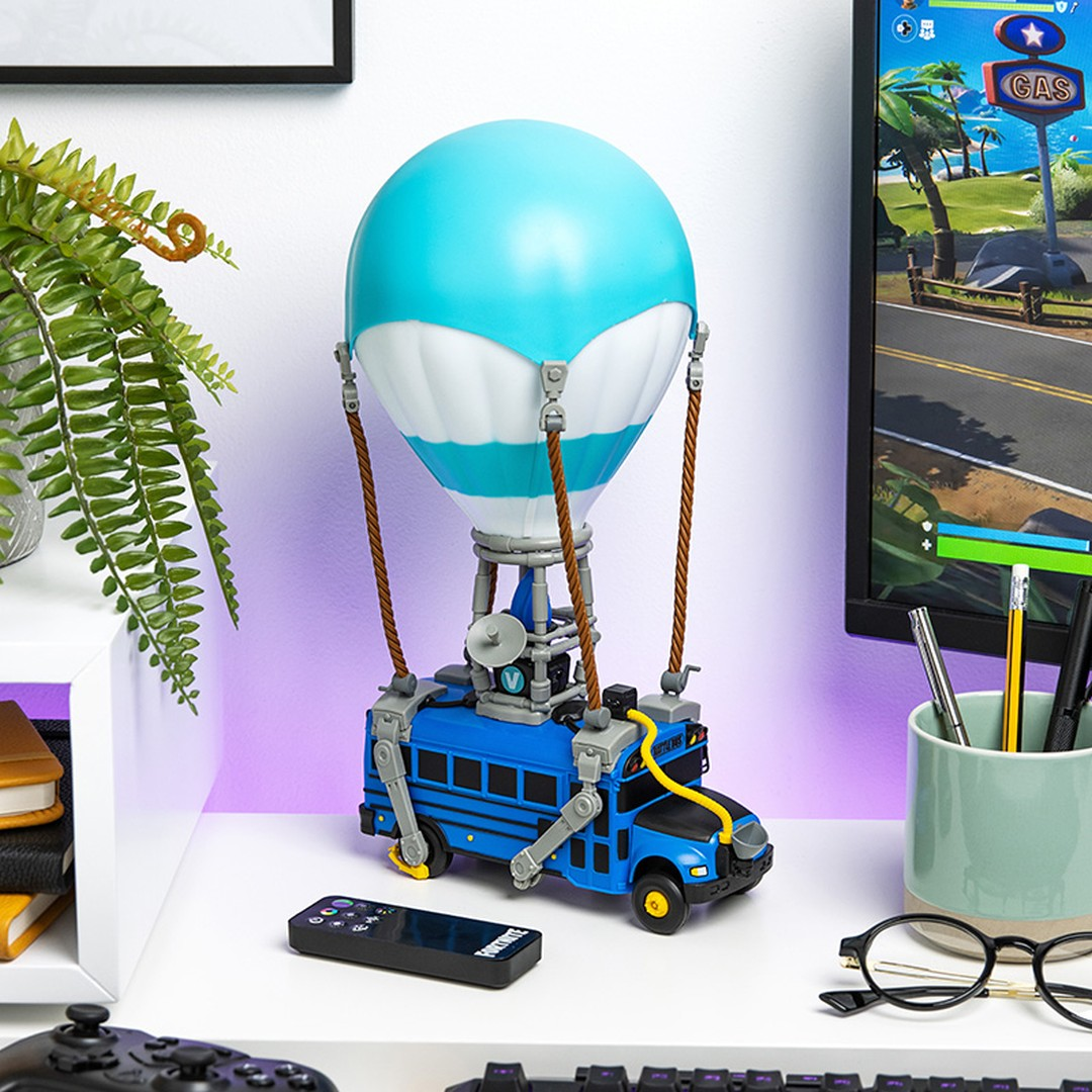 Zabawka Fortnite Battle Bus z balonem, na biurku z monitorem.
