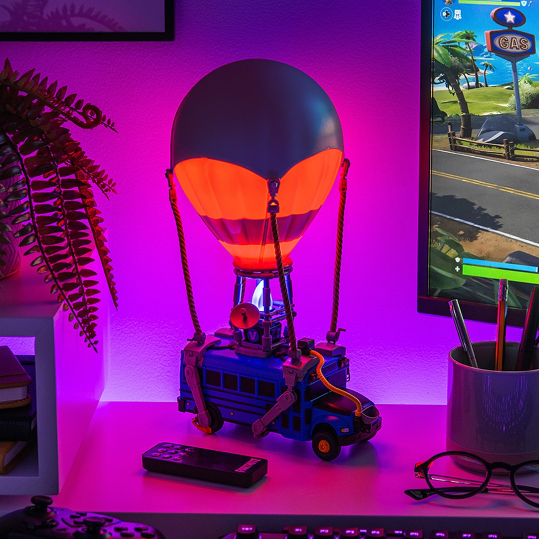 Lampa Fortnite Battle Bus na biurku z zestawem do gier. Fioletowe oświetlenie.