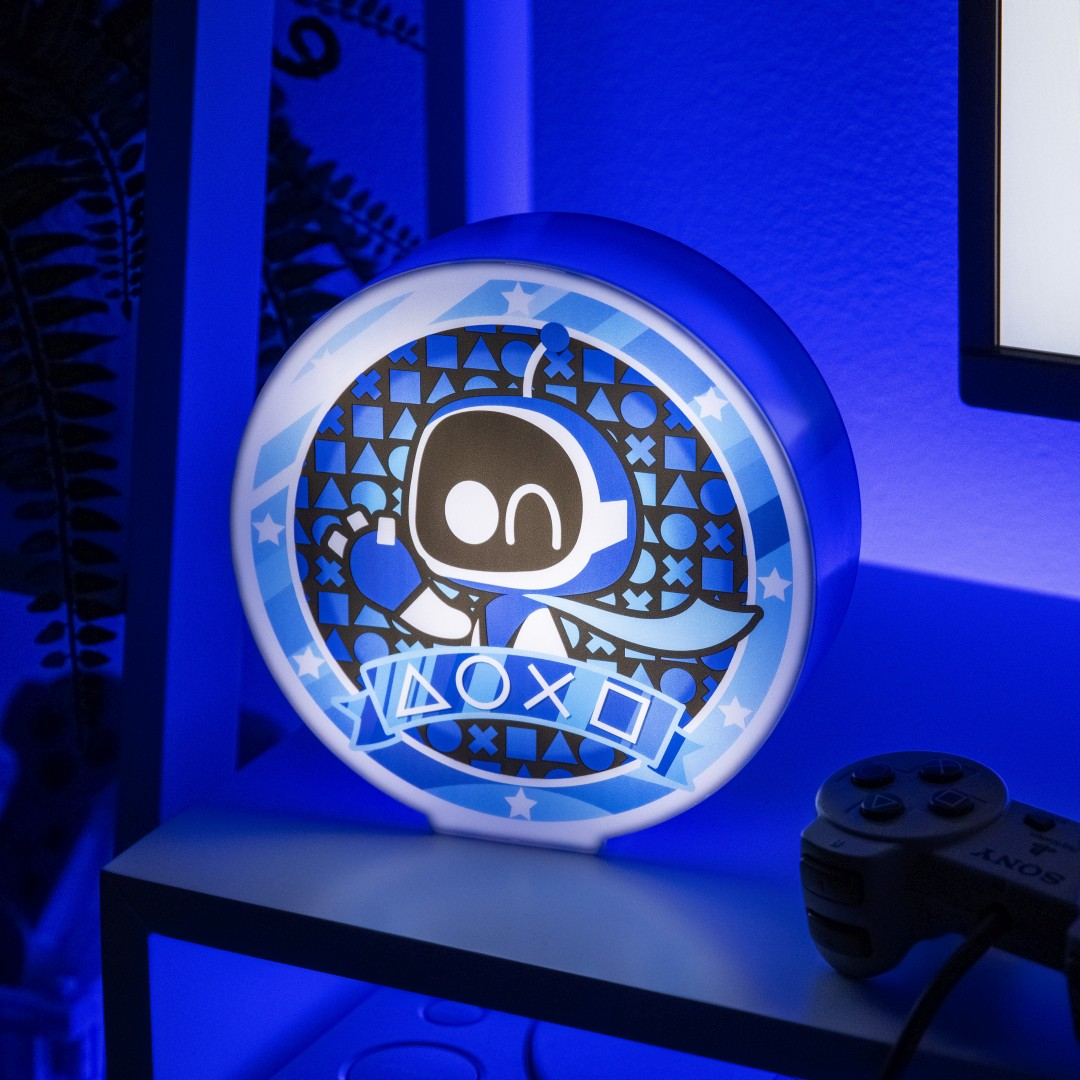 Niebieska lampka Astro Bot z symbolami PlayStation na półce.