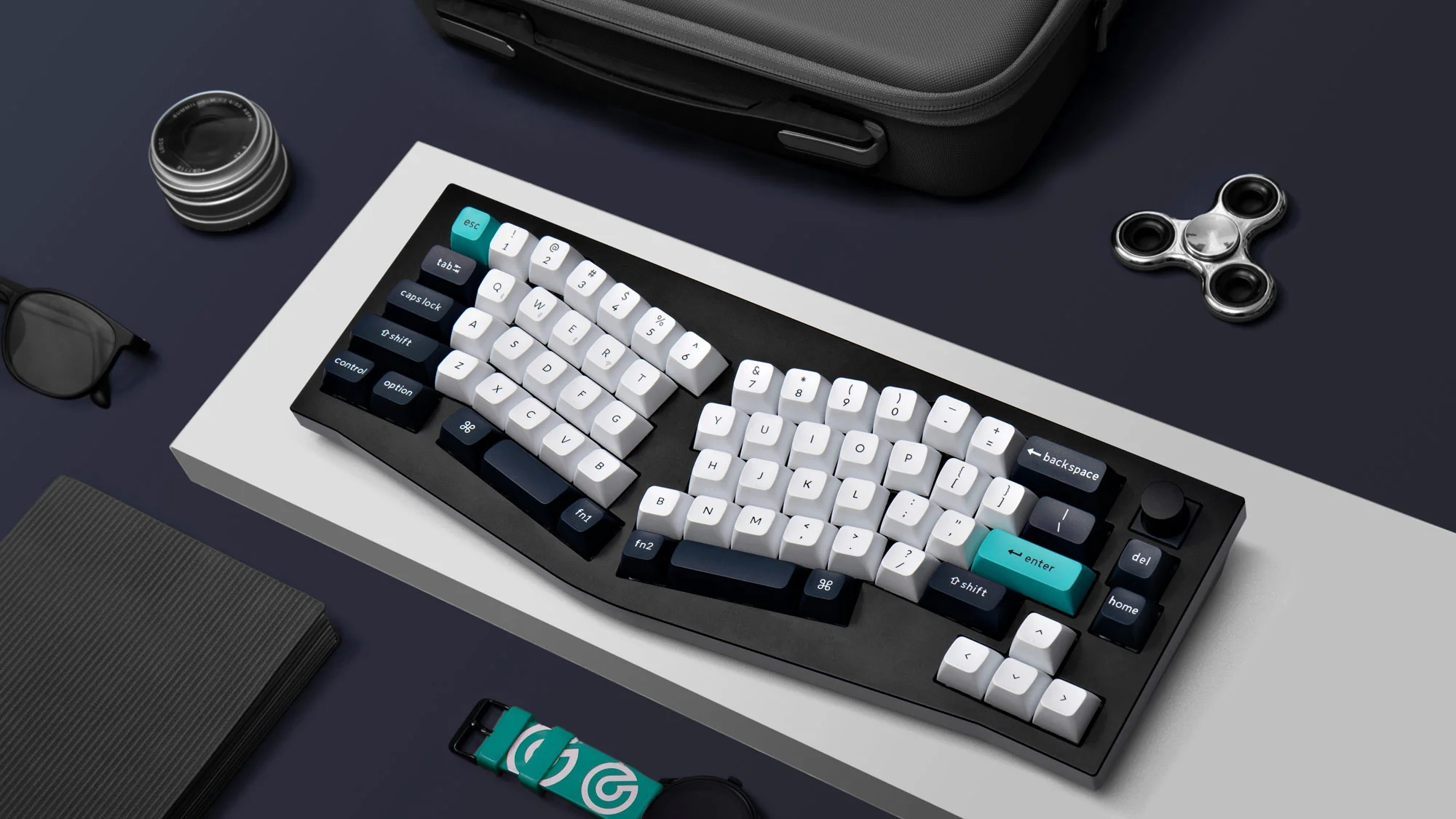 Ergonomiczna czarna klawiatura z torbą na laptopa i akcesoriami.