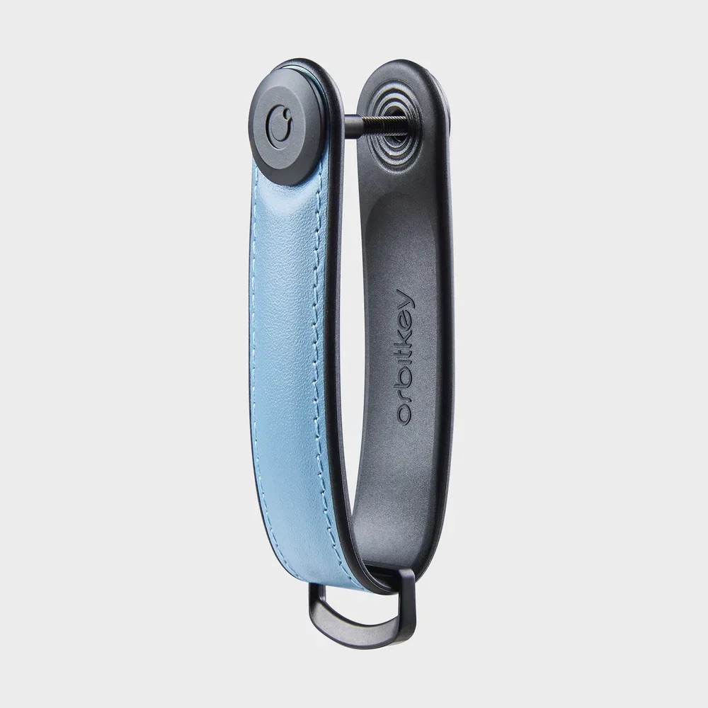 Un organizer per chiavi in pelle blu con componenti in metallo nero.