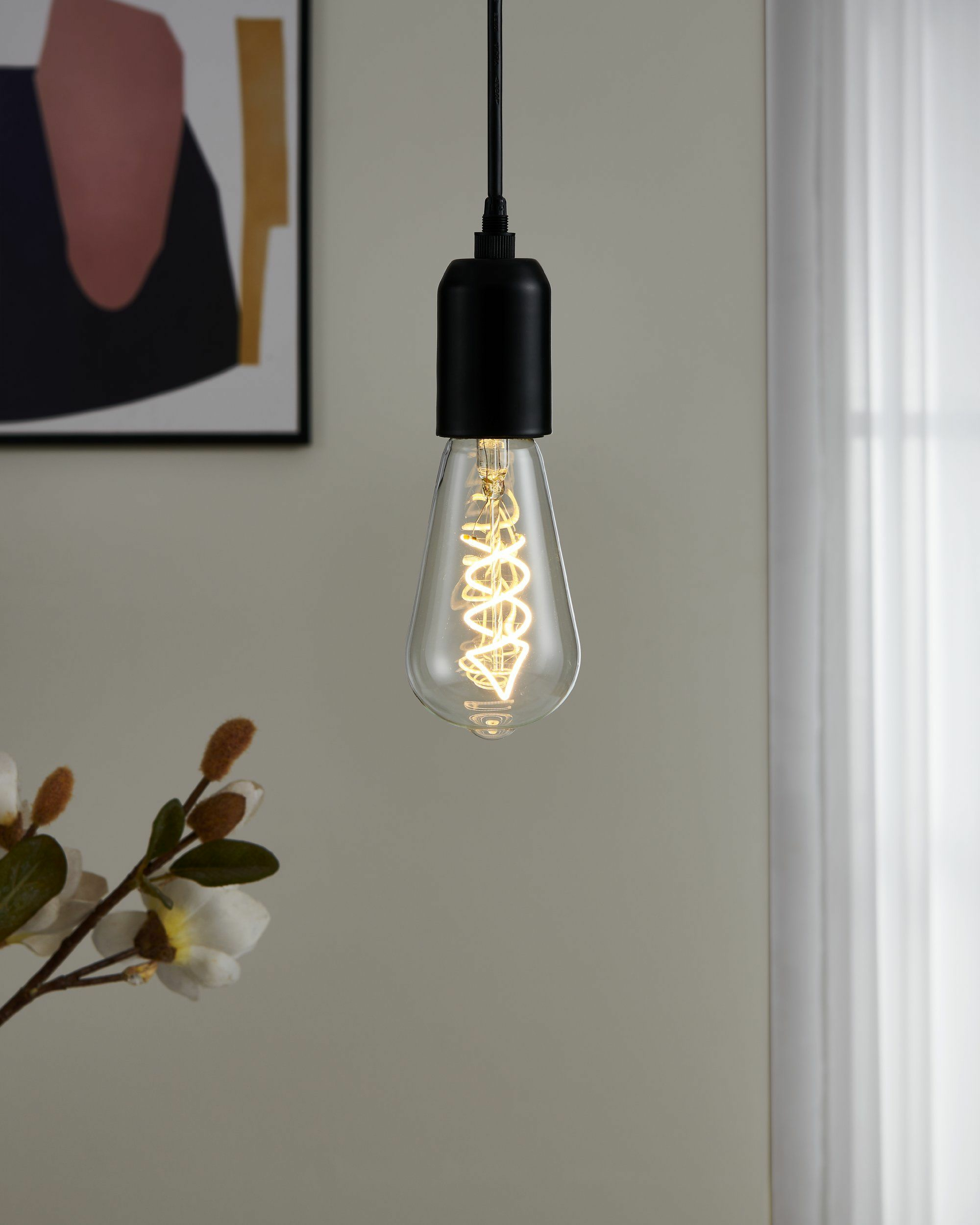 Una lampada a sospensione con portalampada nero e filamento visibile.