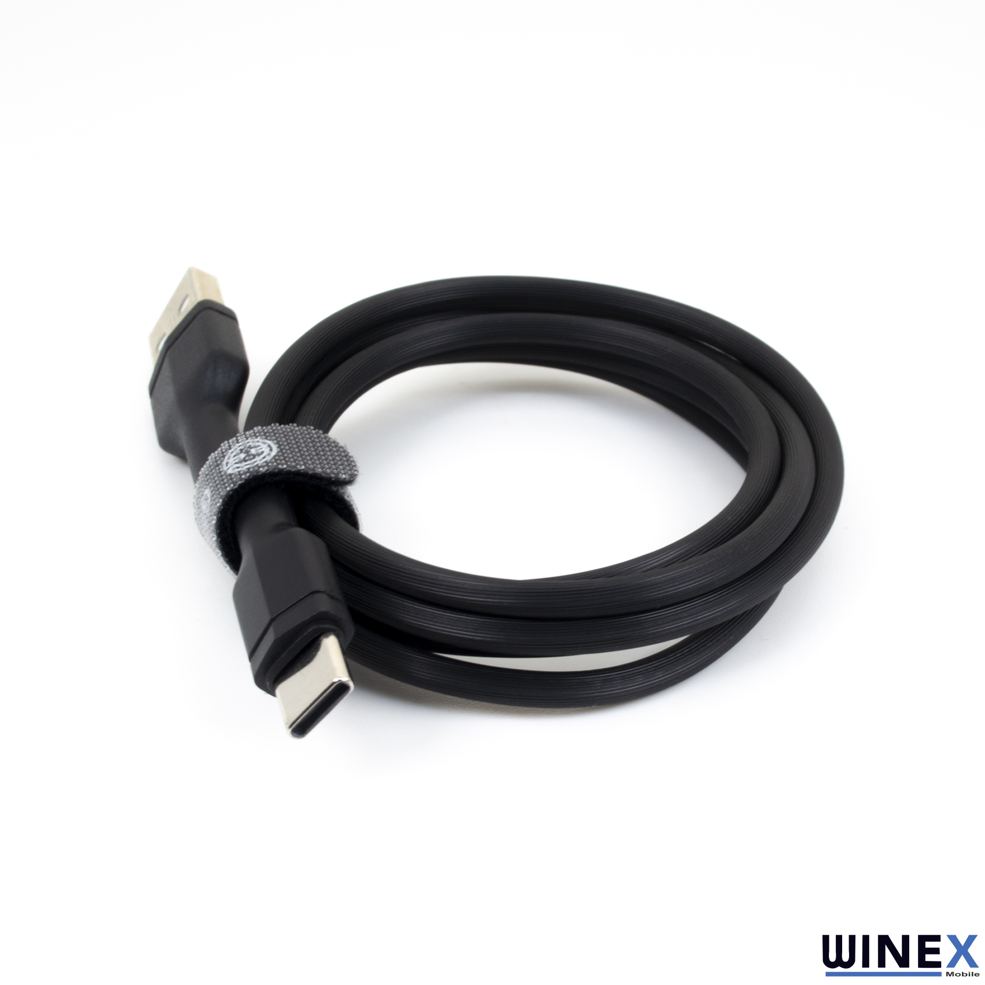 Kumaş örgülü siyah bir USB-C kablosu, cırt cırtlı bantla rulo yapılmış.
