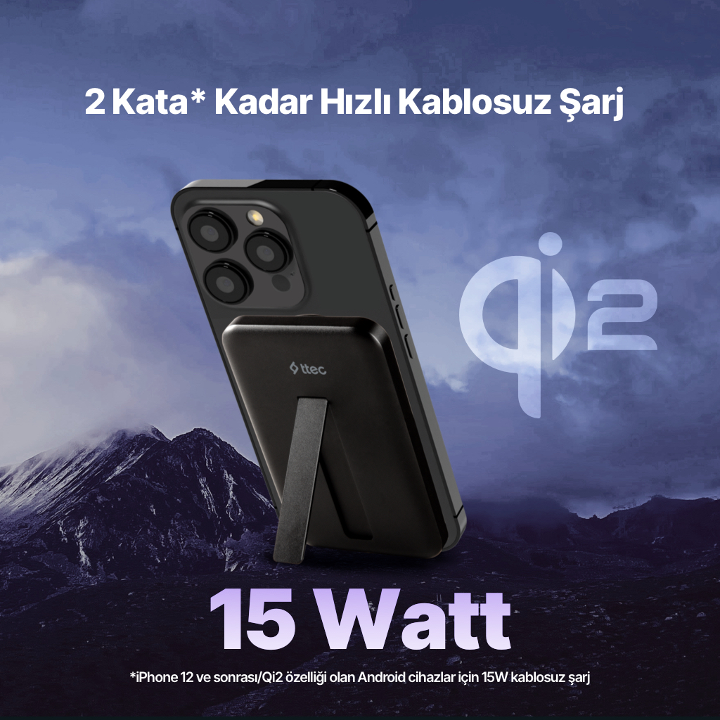 Dağ fonunda kablosuz şarj cihazına bağlı siyah akıllı telefon.