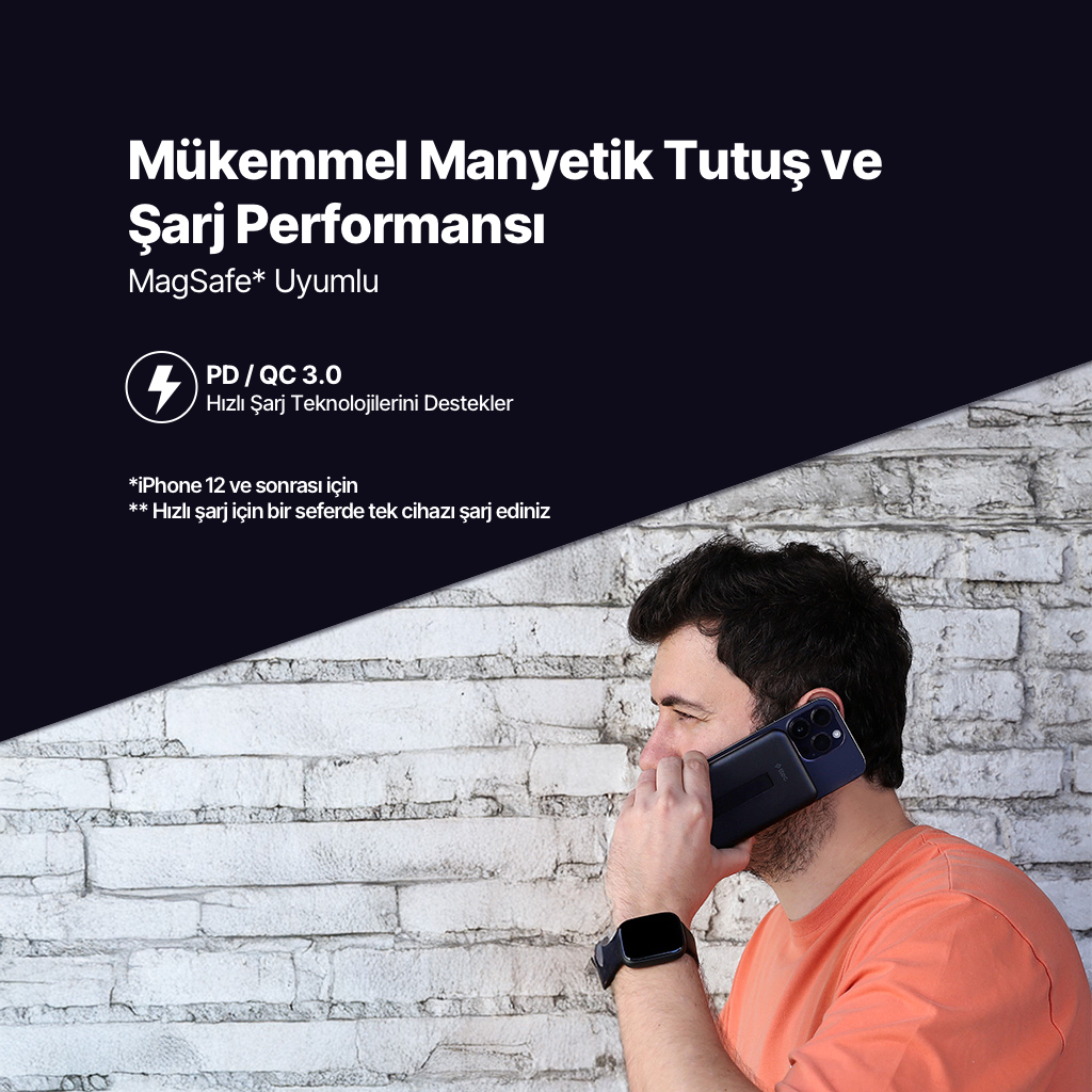 Erkek, beyaz tuğla duvara karşı telefon ve şarj cihazı tutuyor. MagSafe hakkında.