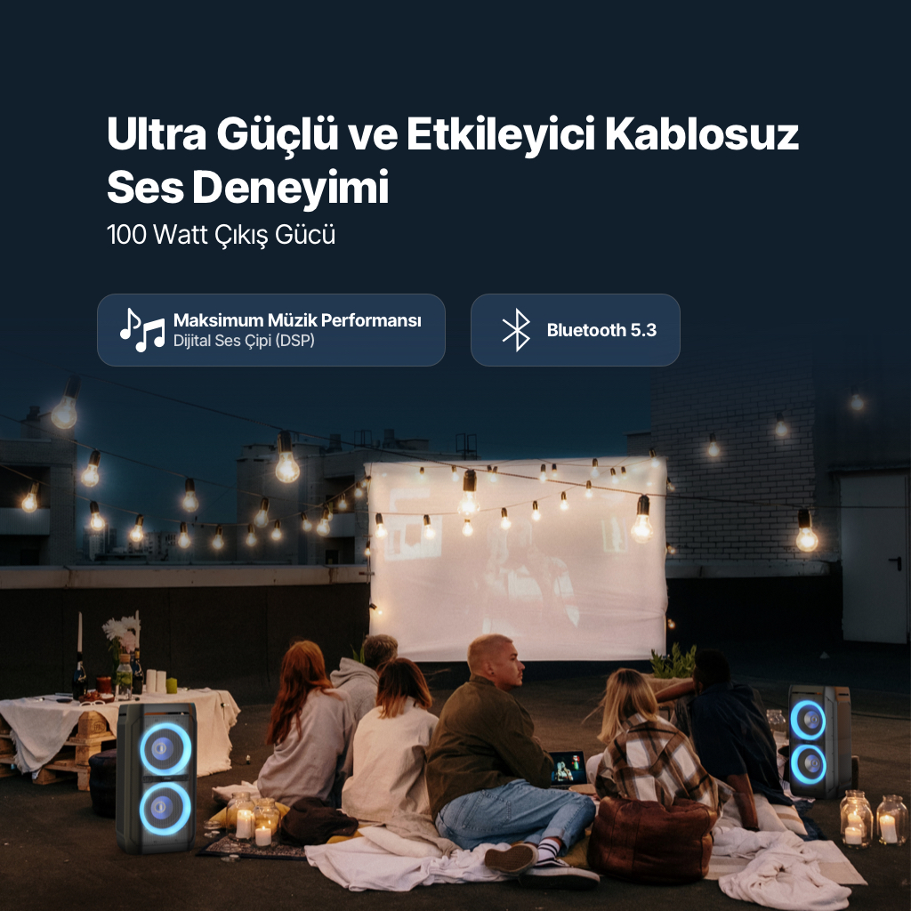 Arkadaş grubu, hoparlörler ve projeksiyonla ışık zincirleri altında film izliyor.