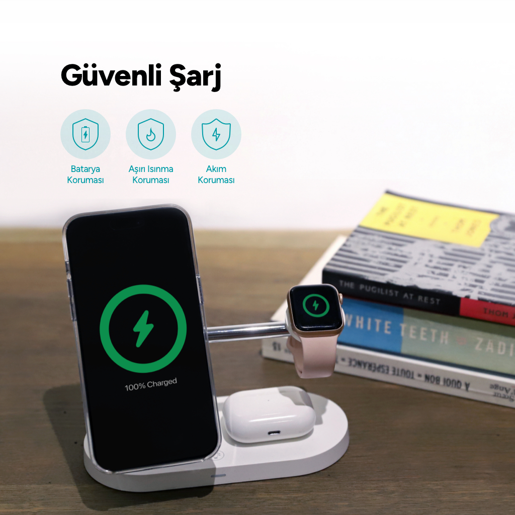 Şarj istasyonunda telefon, akıllı saat ve kulaklık. Arkada kitaplar.