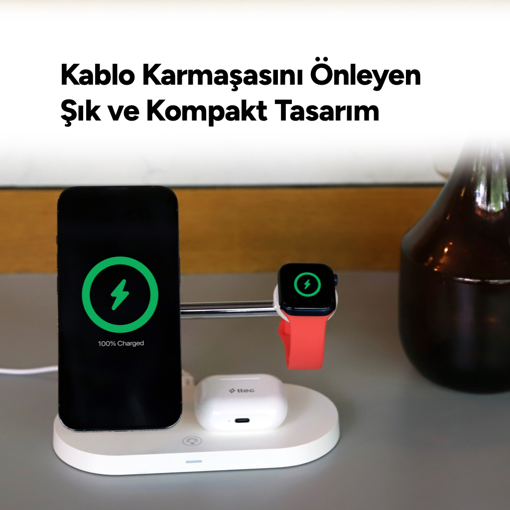 Beyaz bir şarj istasyonunda iPhone, Apple Watch ve AirPods şarj oluyor.