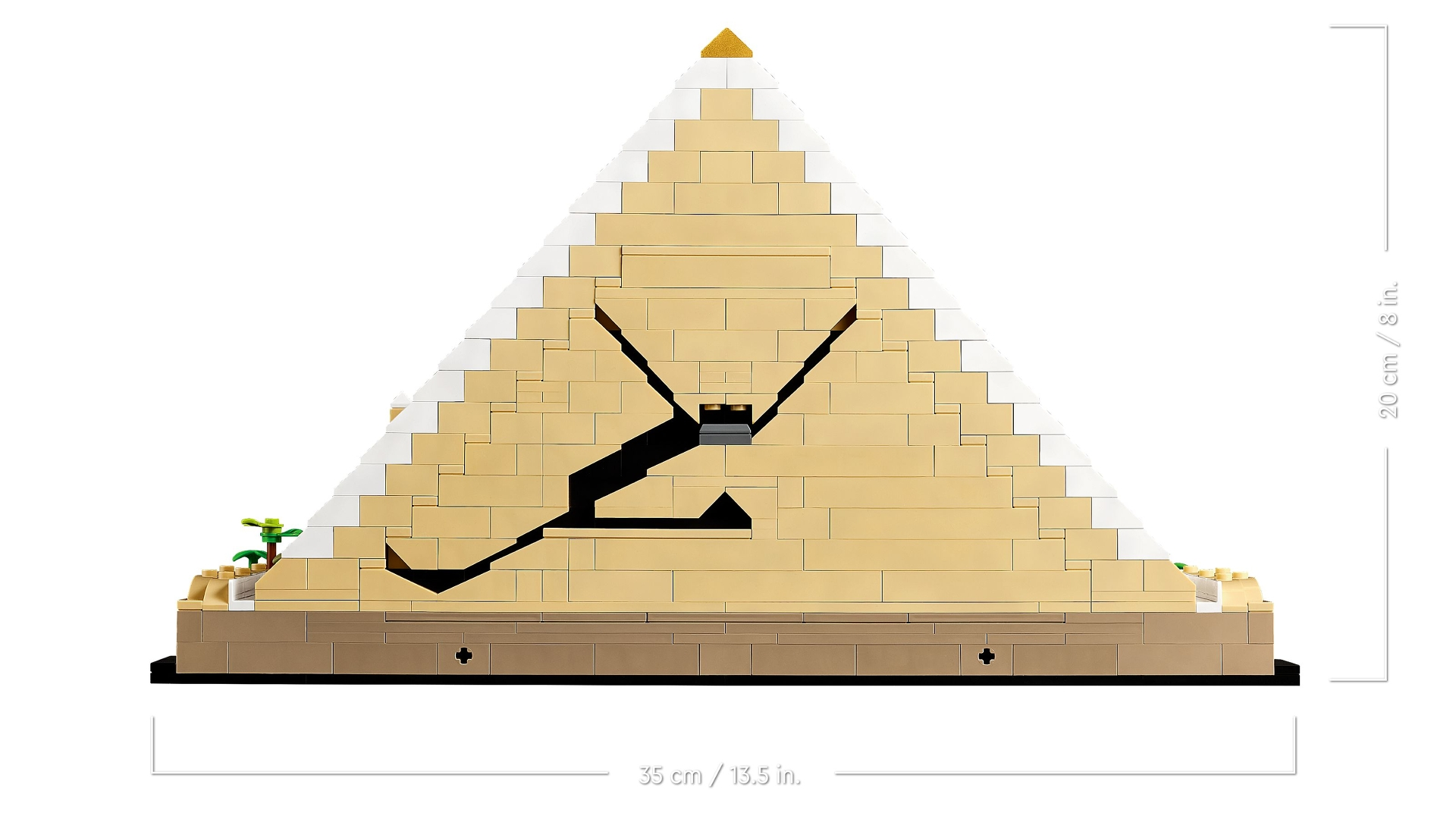 Ein Lego-Modell einer Pyramide mit einer Wüstenlandschaftsbasis und einer kleinen grünen Pflanze.