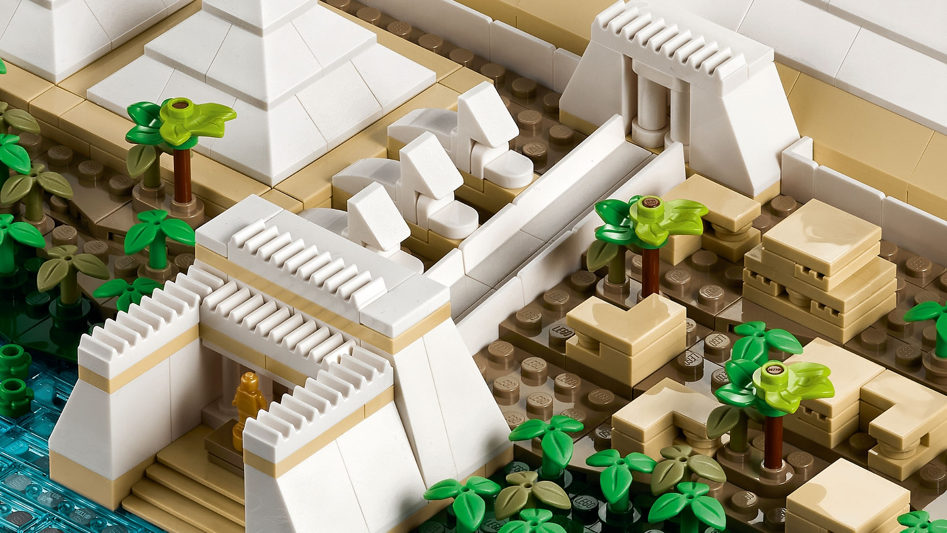 Ein Lego-Modell einer antiken Stätte mit Pyramiden, Vegetation und Wasser.