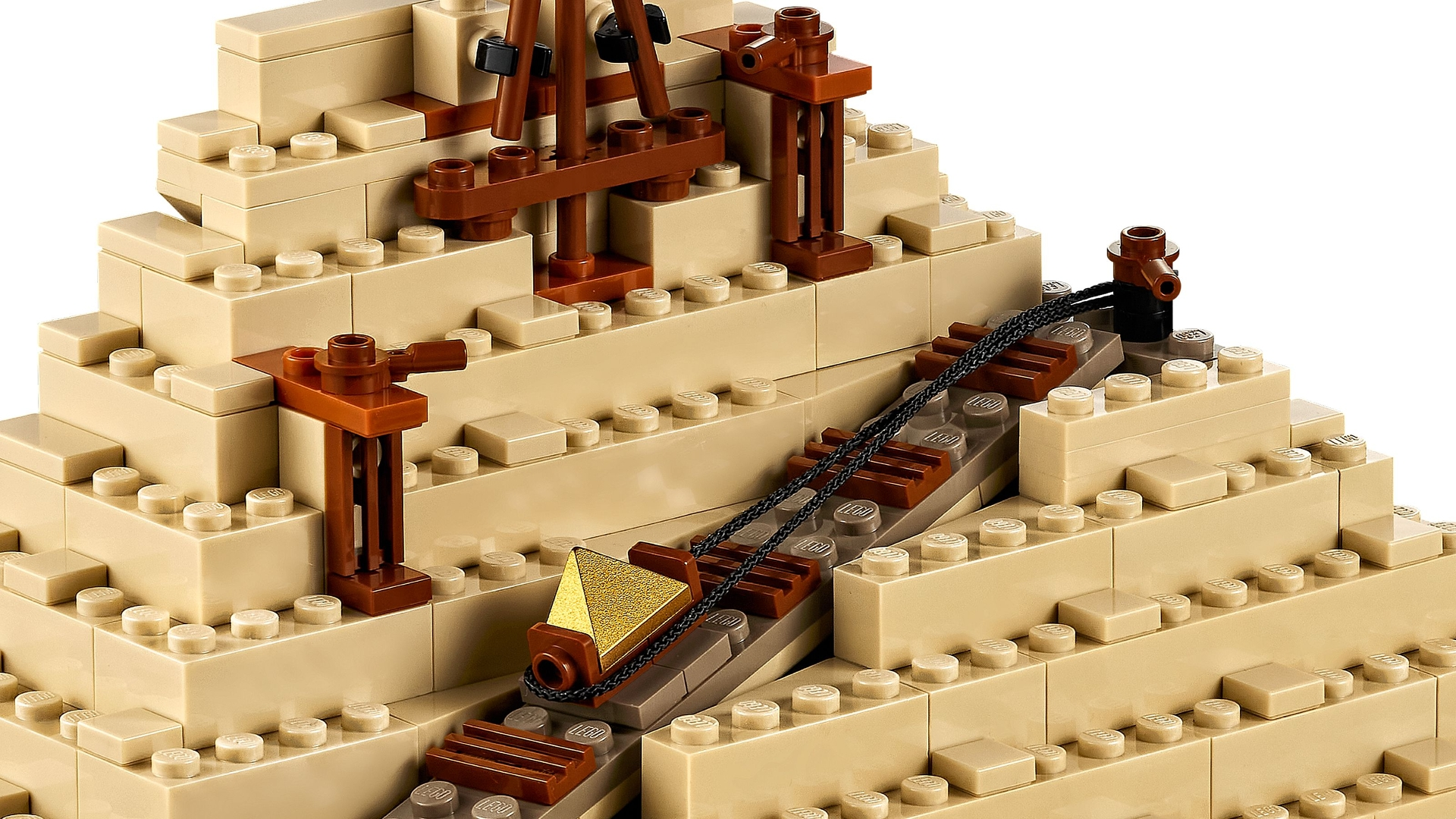 Ein goldener Pyramidenanhänger an einer Schnur hängt von einer LEGO-Pyramidenkonstruktion.