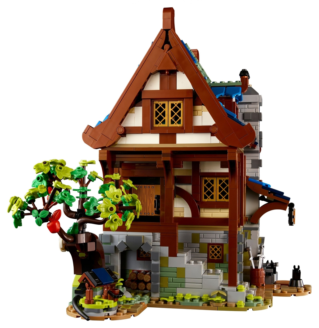 Ein LEGO-Fachwerkhaus mit Baum, Brunnen und Holzstapel.