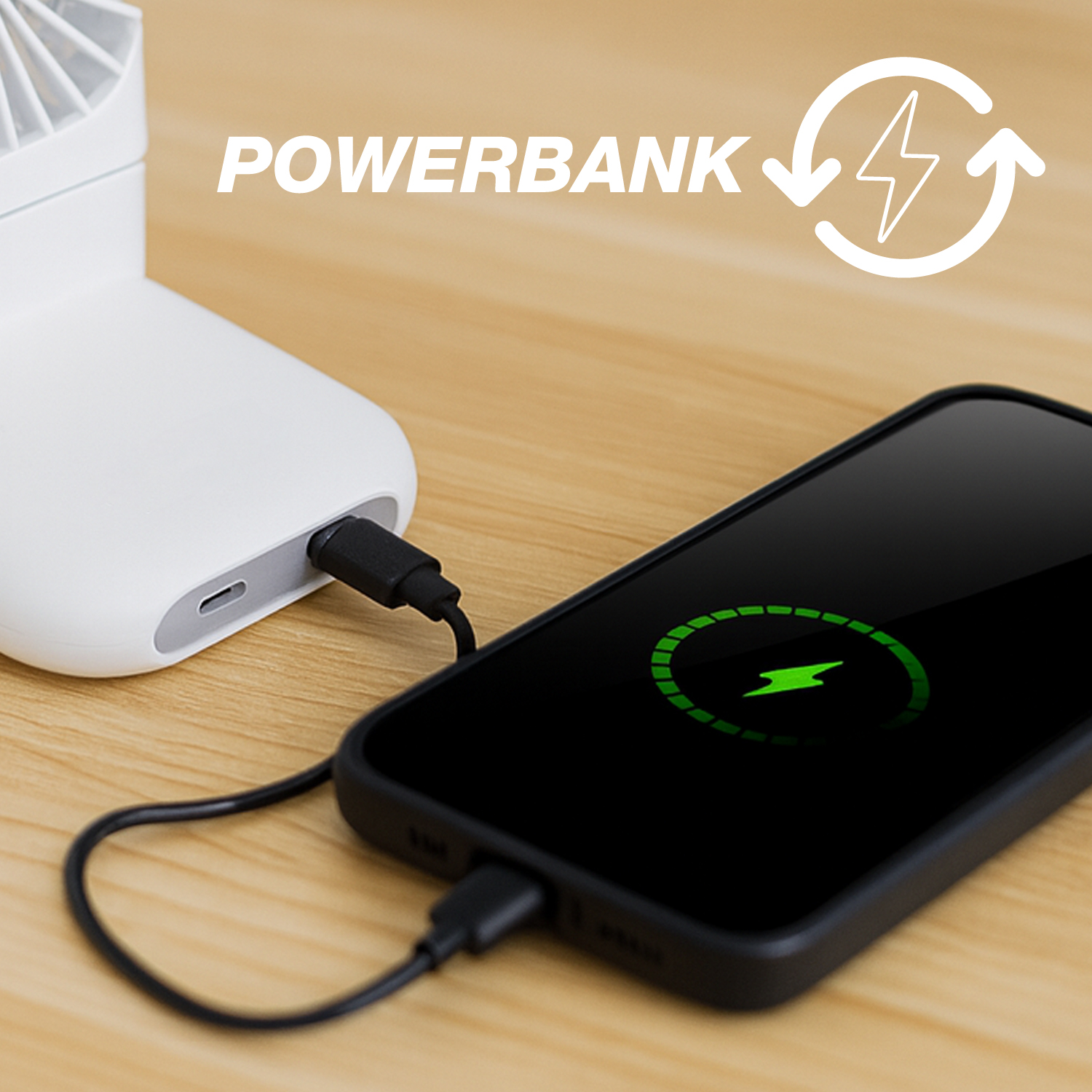 Un power bank bianco carica uno smartphone nero su un tavolo di legno.