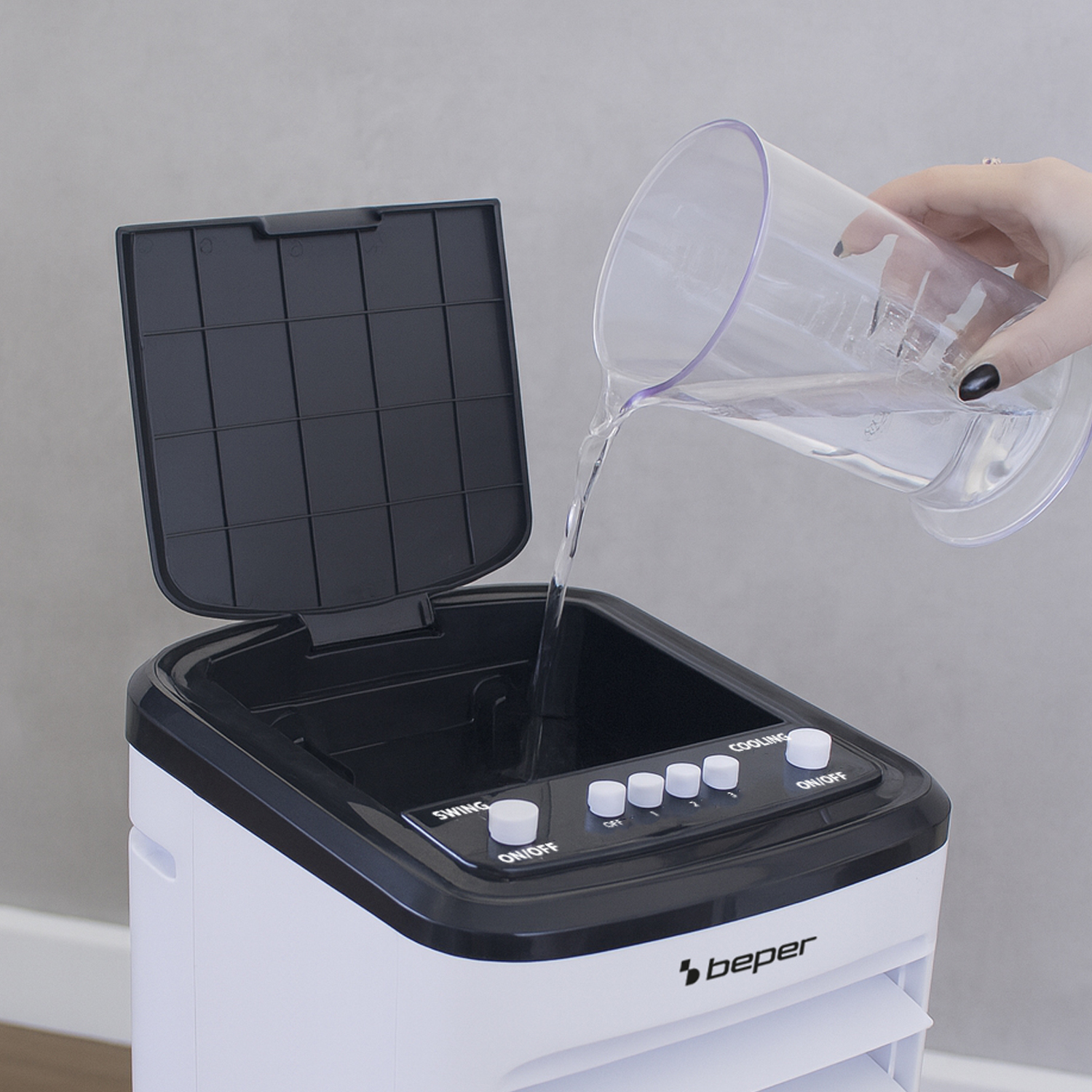 L'acqua viene versata in un climatizzatore bianco con il coperchio aperto.