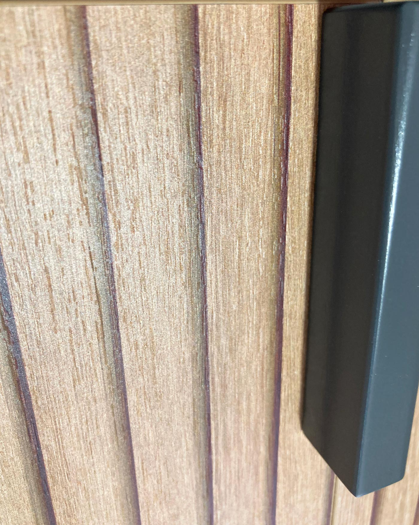 Textura de grano de madera con un elemento vertical oscuro a la derecha.