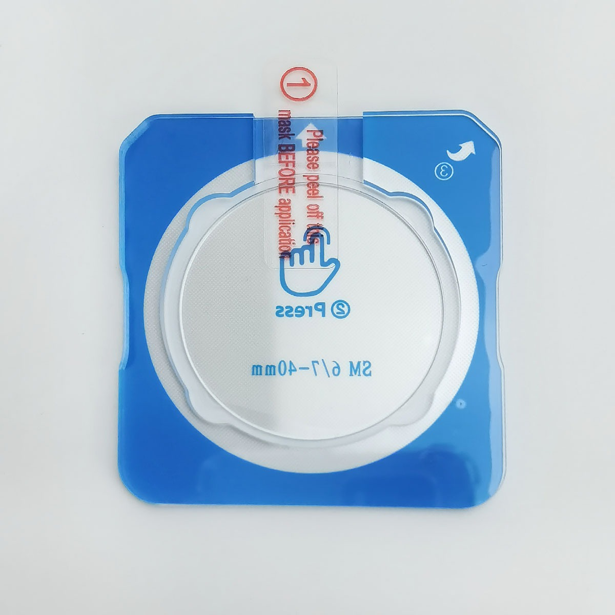 Un adesivo blu con un inserto rotondo e argentato, che mostra istruzioni per rimuovere una maschera.