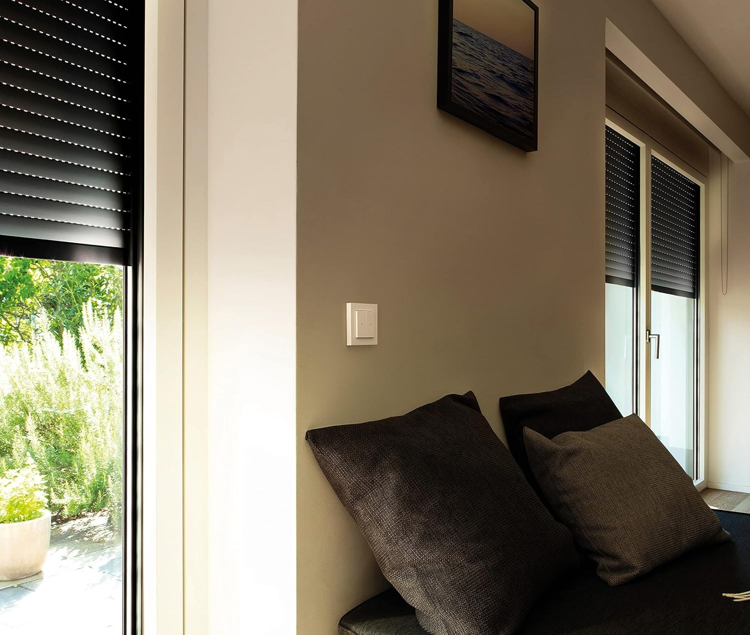 Ein Wohnzimmer mit Kissen, Rollläden und einem Bild an der Wand.