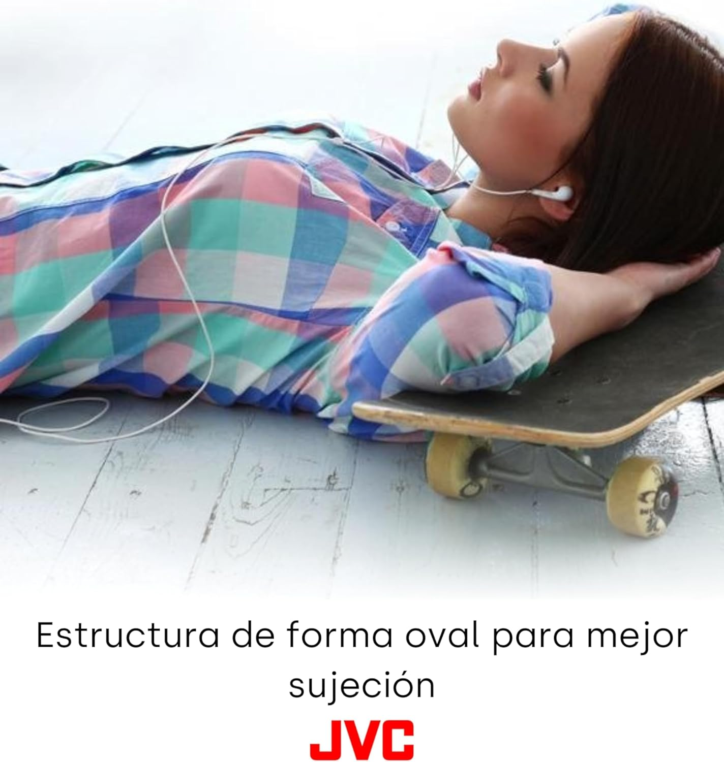 Mujer tumbada en monopatín, escuchando música con auriculares, camisa de cuadros.
