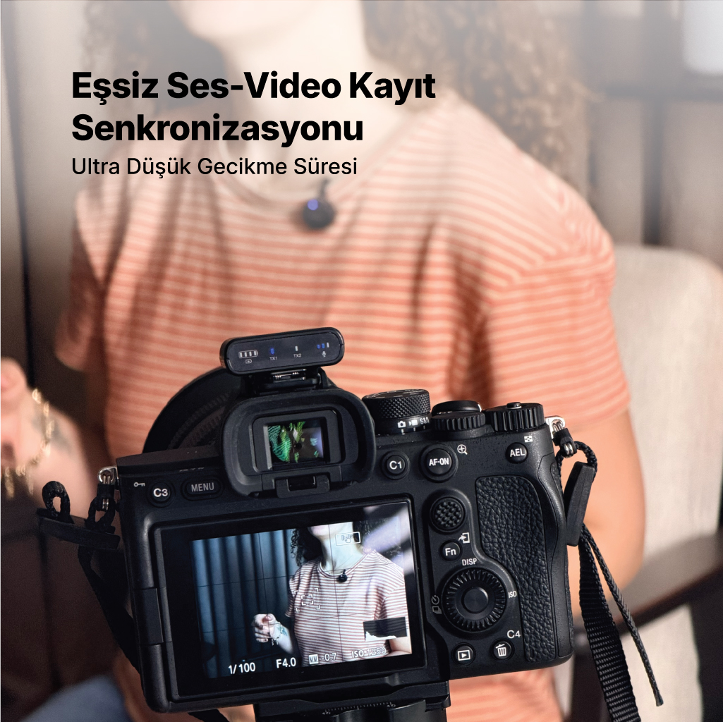 Kamera mikrofonlu ve arka planda metinli. Kameraya odaklanılmış.