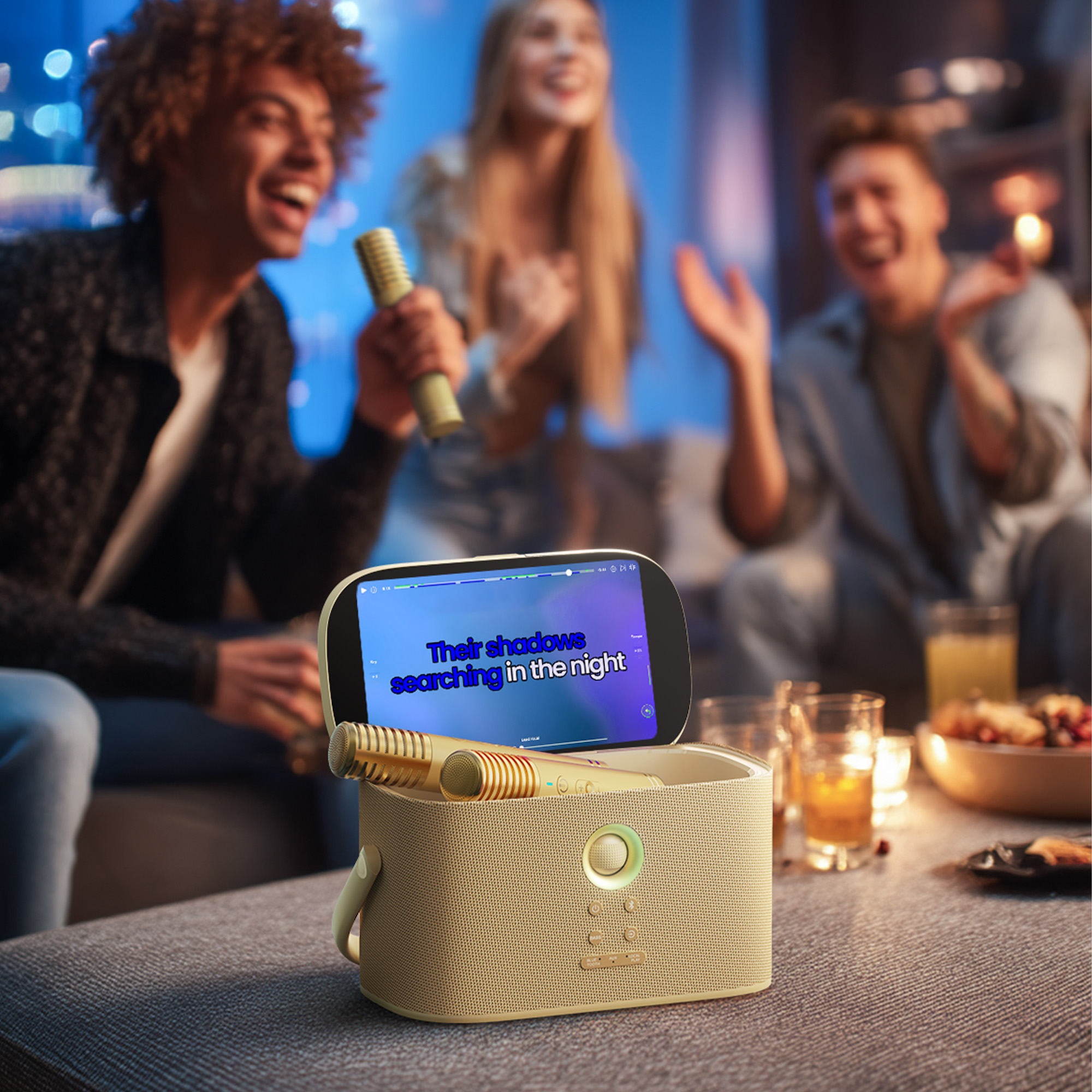 Arkadaşları mikrofonlar ve ekranlı hoparlörle karaoke söylüyor.