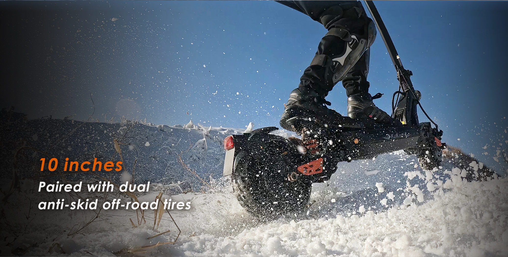 Uno scooter elettrico corre sulla neve, focalizzato sulle ruote e sul conducente.