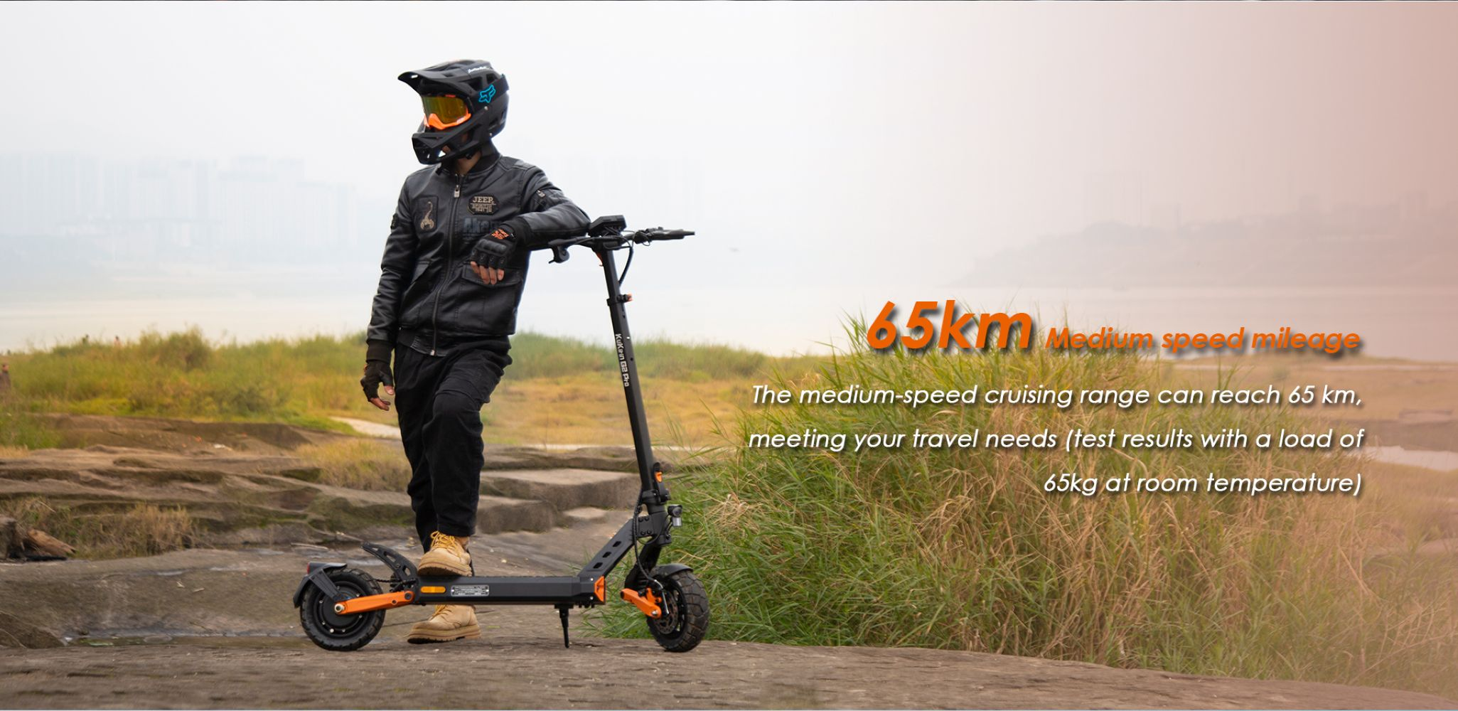 Una persona in abbigliamento da moto si appoggia a uno scooter elettrico all'aperto.