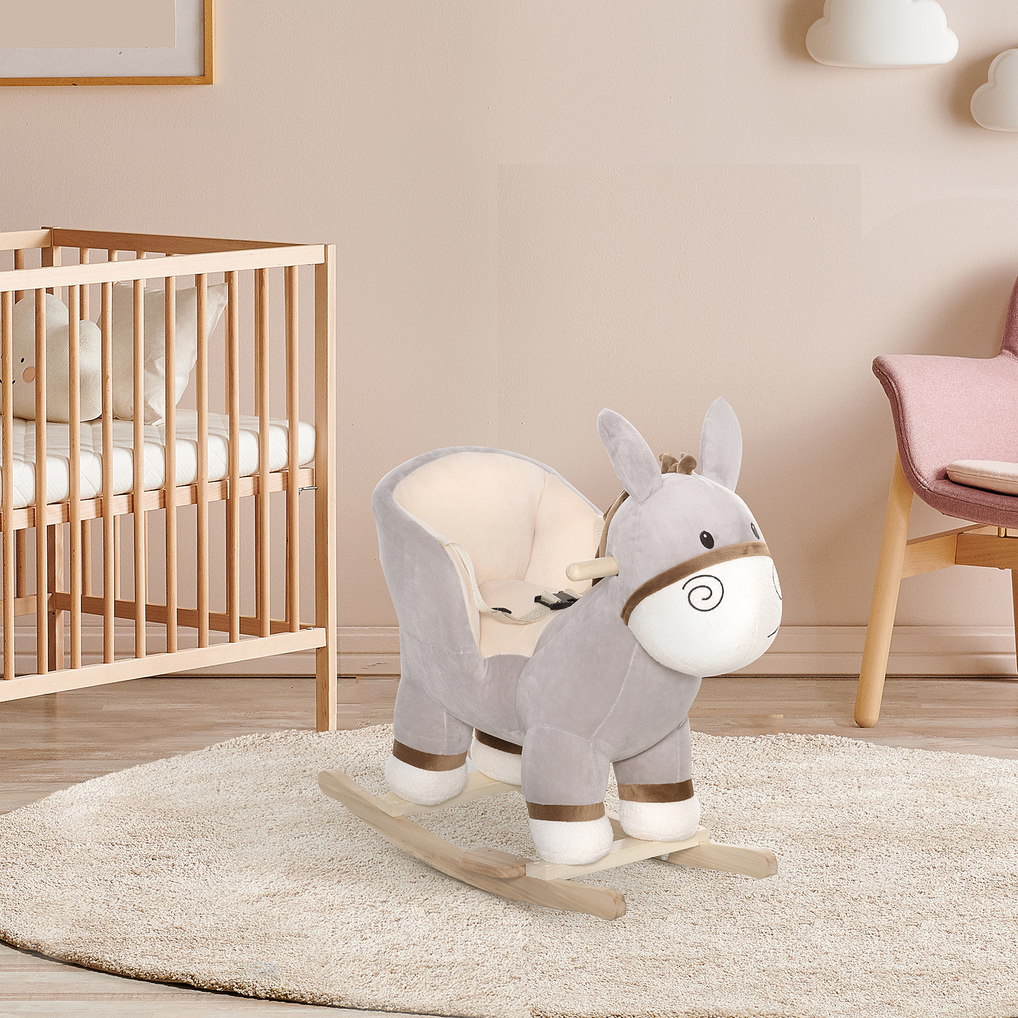 Un balancín de peluche con forma de burro se encuentra sobre una alfombra crema en una guardería con cuna y silla rosa.