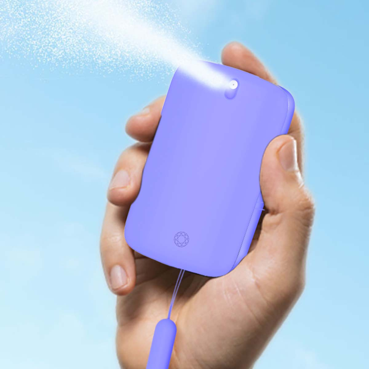 Una mano tiene un flacone spray viola che emette una nebbia fine.
