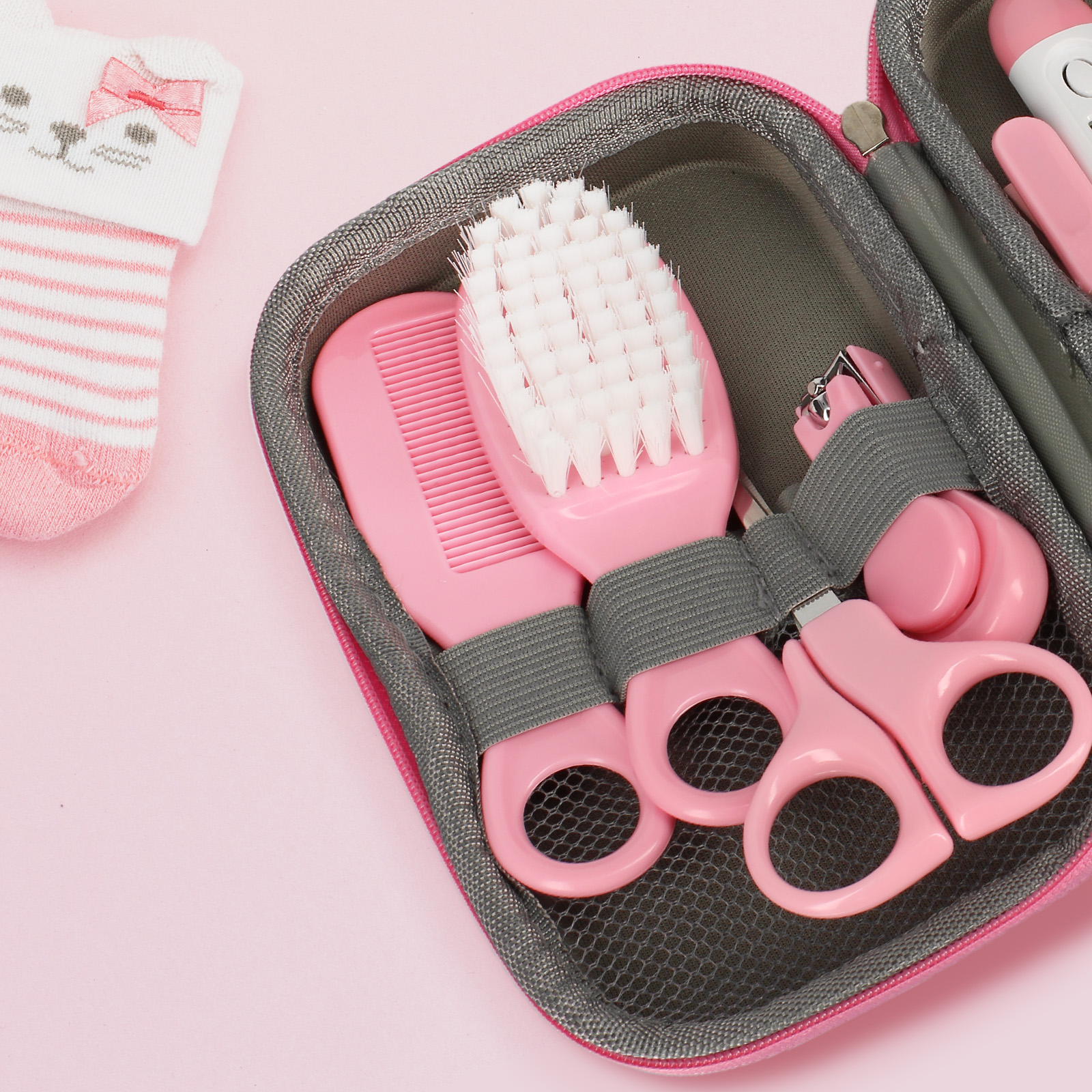 Organizzatore rosa per kit toeletta neonato con pettine, spazzola, tagliaunghie e calzino.