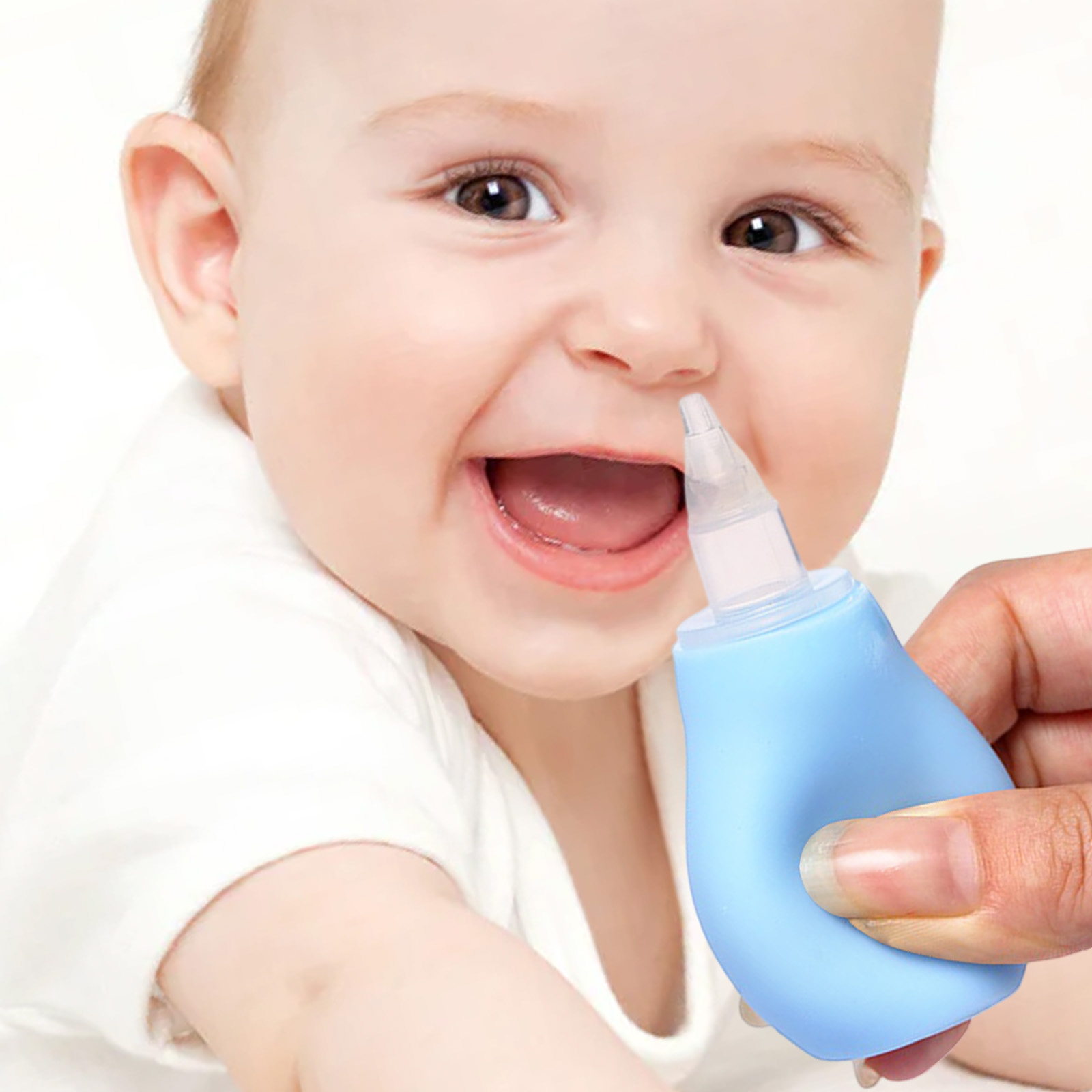 Un bambino sorride mentre una mano tiene un aspiratore nasale blu.