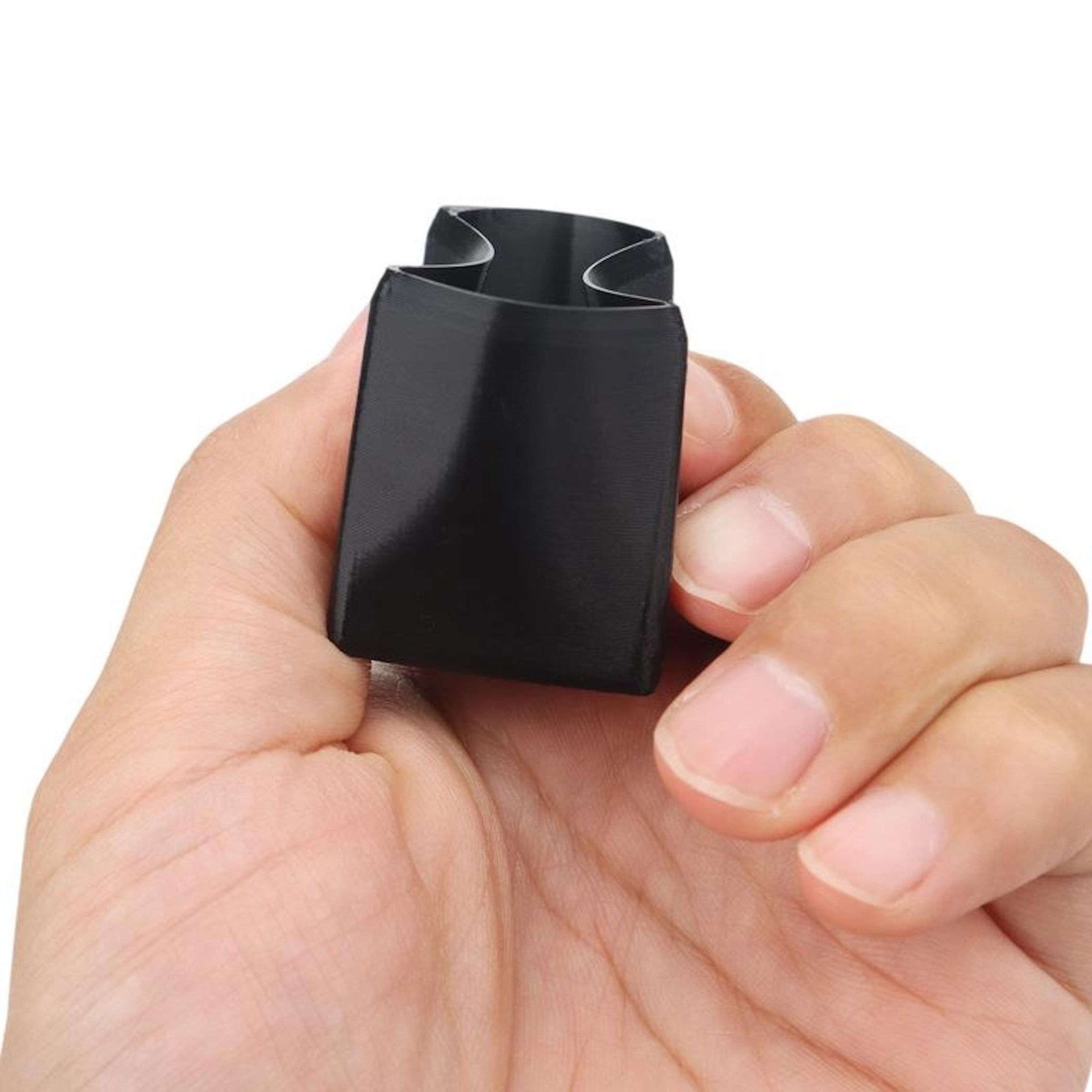 Eine Hand hält ein kleines schwarzes Objekt mit einer gebogenen Form.