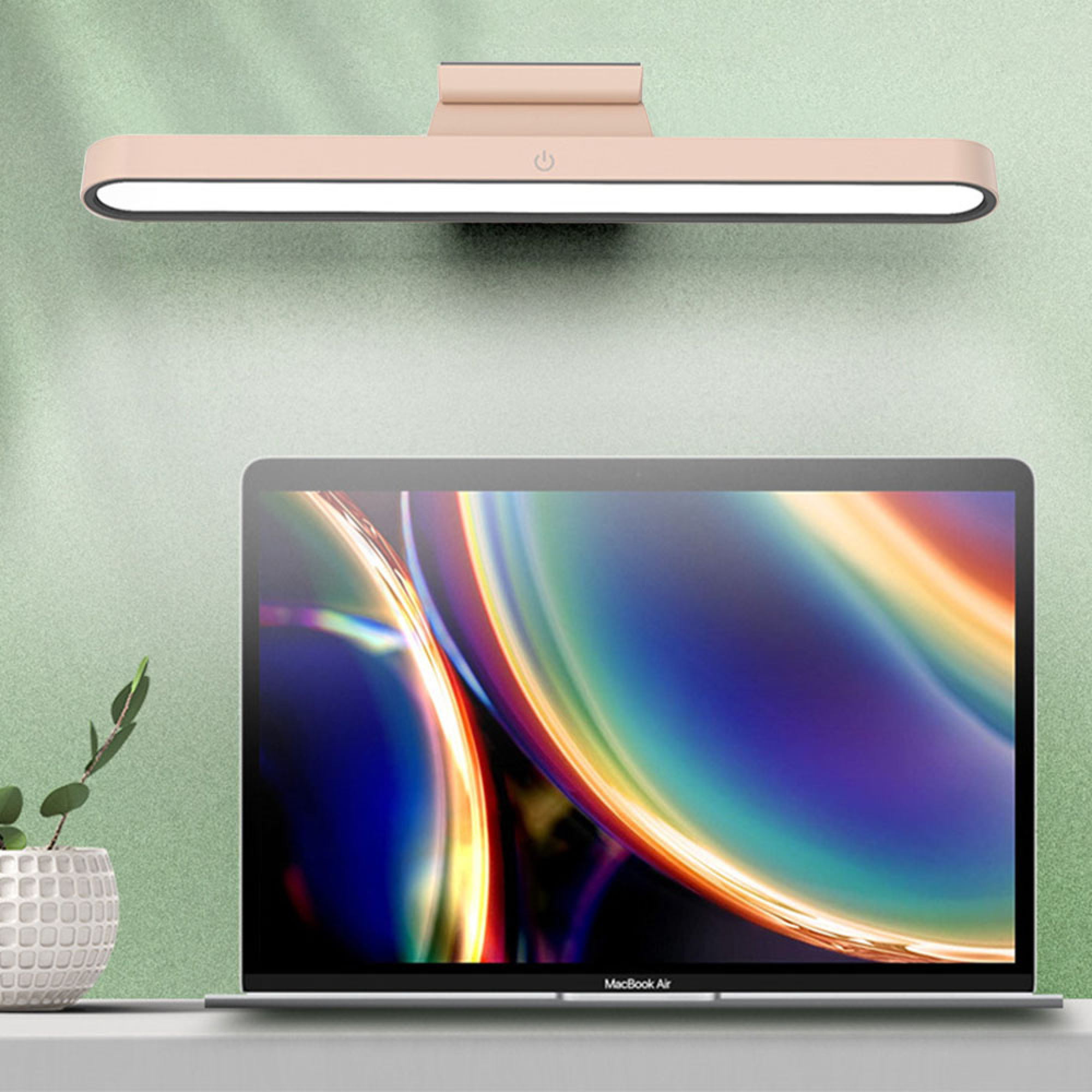 Ein hellrosa Laptoplicht mit einem Ein/Aus-Symbol über einem offenen MacBook Air.