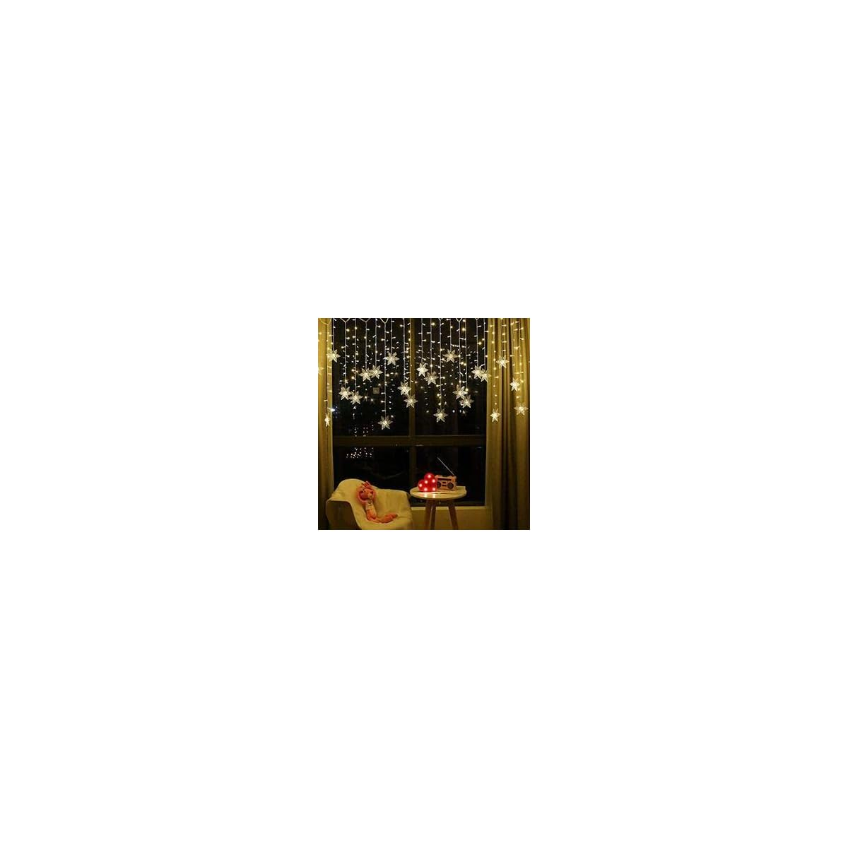 Fenster mit Sternenlichterkette, Sessel und Tisch mit roten Kugeln.