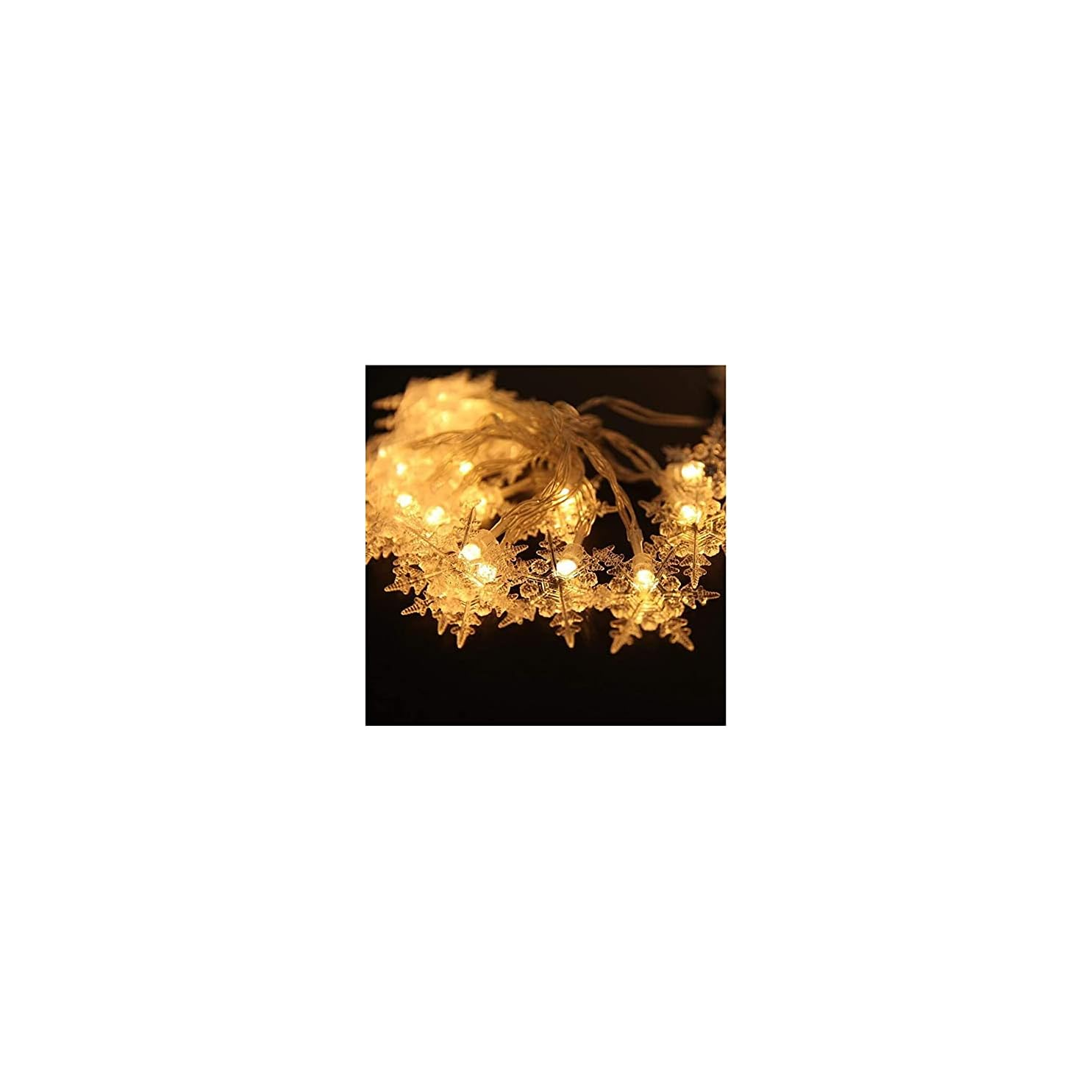 Eine Lichterkette mit warmweißen, schneeflockenförmigen LEDs auf dunklem Hintergrund.