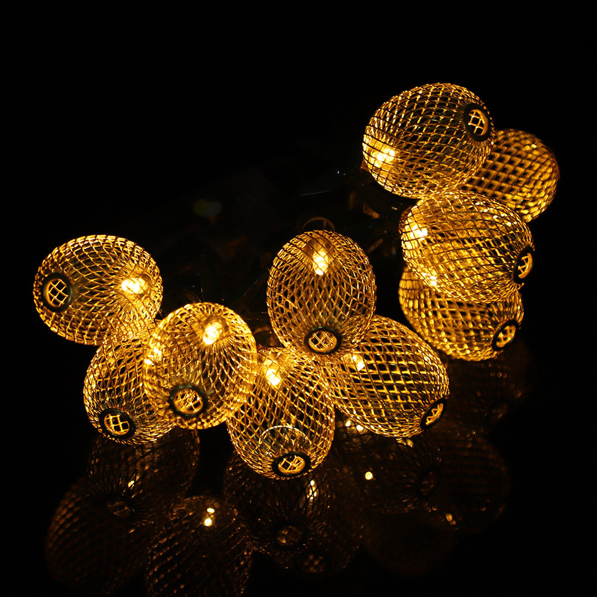 Goldene Lichterkettenkugeln mit Gitternetzmuster auf schwarzem Hintergrund.