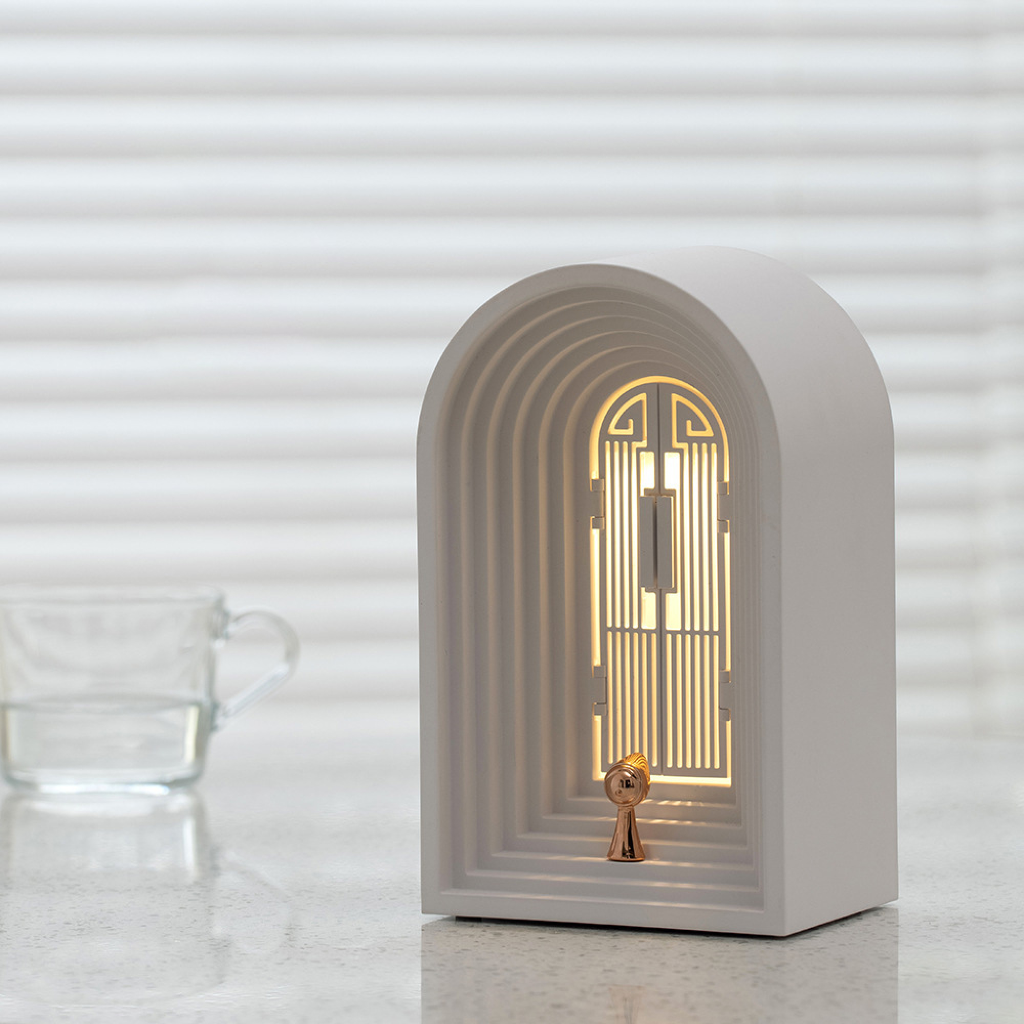 Ein weißer Architekturlampen-Nachttisch mit goldenem Schlüsselloch-Detail.
