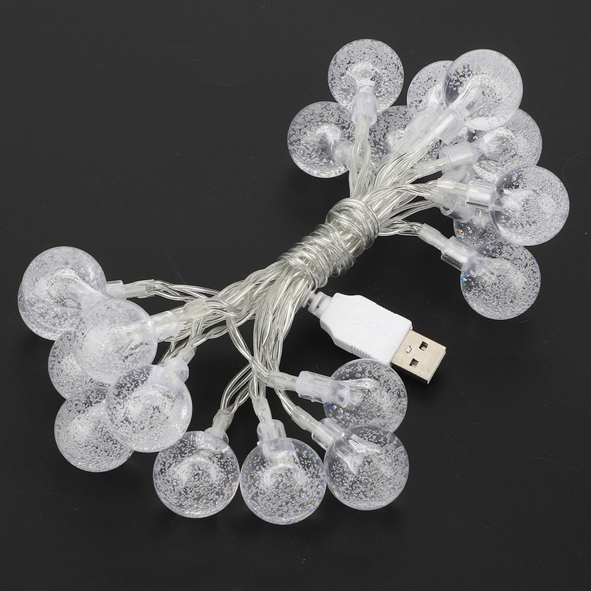 Eine USB-Lichterkette mit durchsichtigen Glaskugeln, gefüllt mit Glitzer, auf schwarzem Hintergrund.