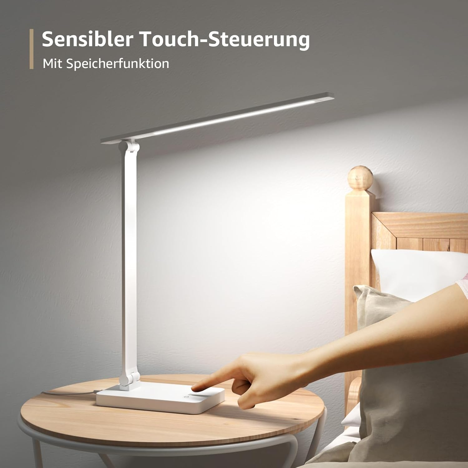 Eine weiße Tischlampe mit Touch-Steuerung auf einem Nachttisch neben einem Bett.