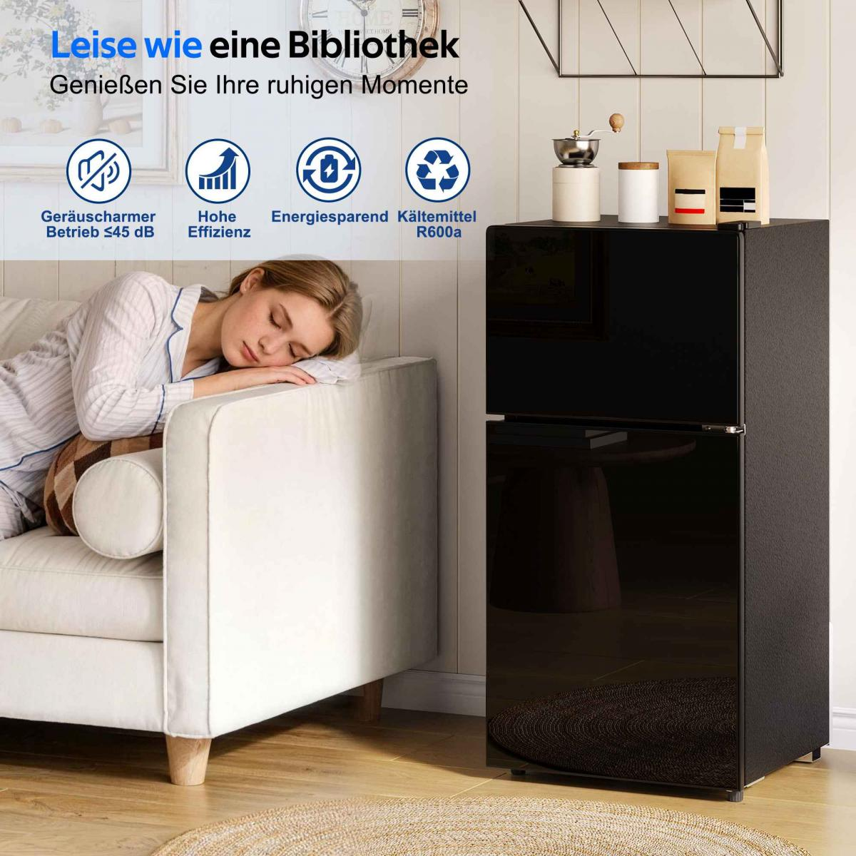 Eine Frau schläft auf einem Sofa neben einem schwarzen Kühlschrank.