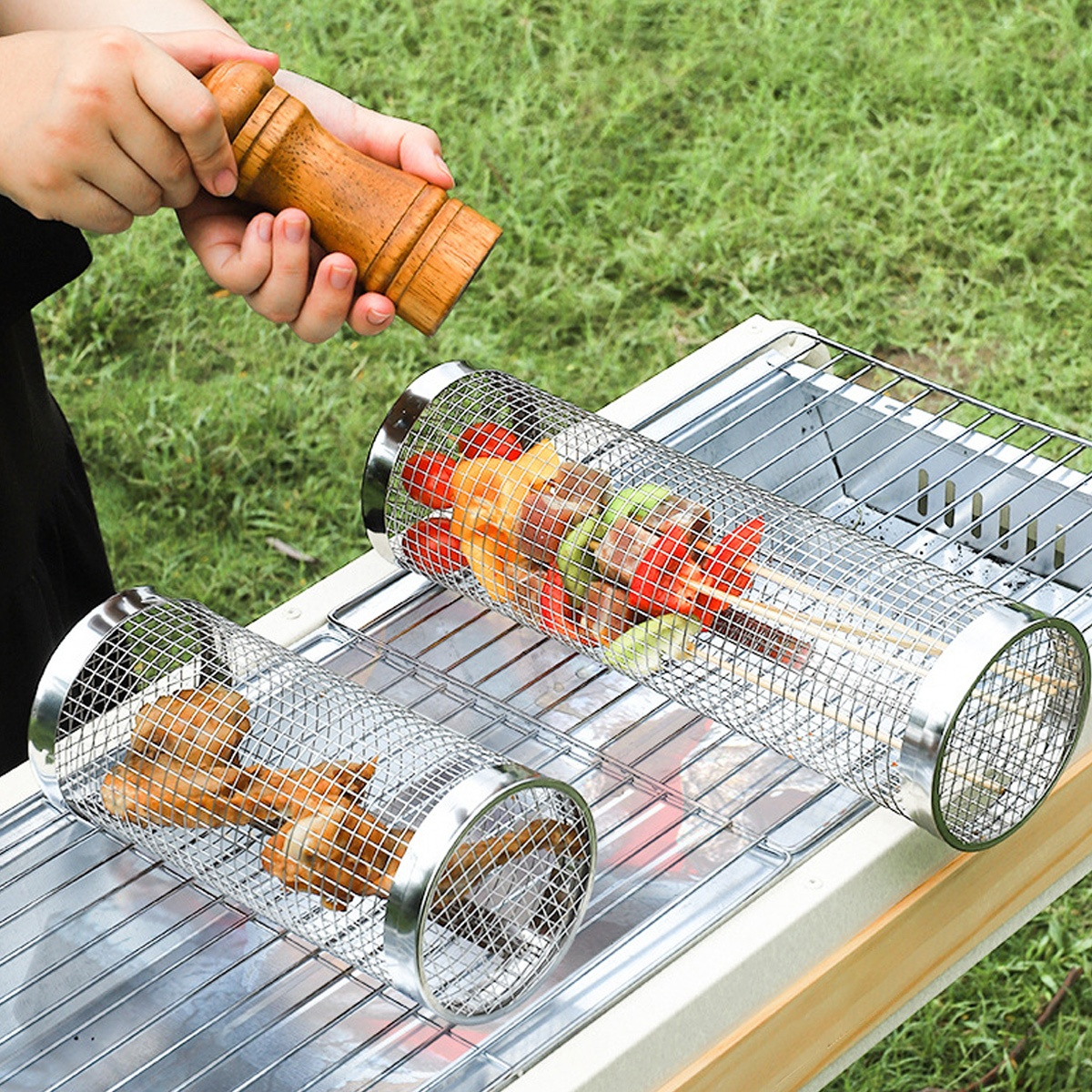 Hände würzen Spieße in Metallkörben auf einem Grill, mit Essen darin.